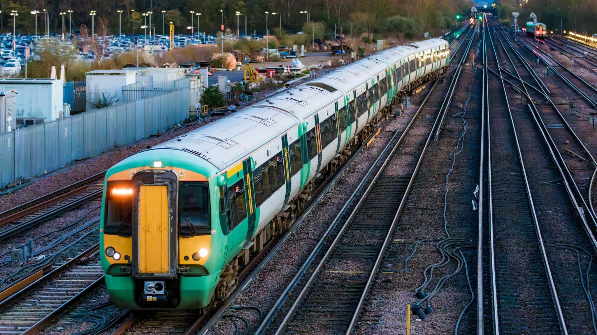 High angle view of a green Southern passenger train in the early evening waiting to depart the station at Gatwick Airport.