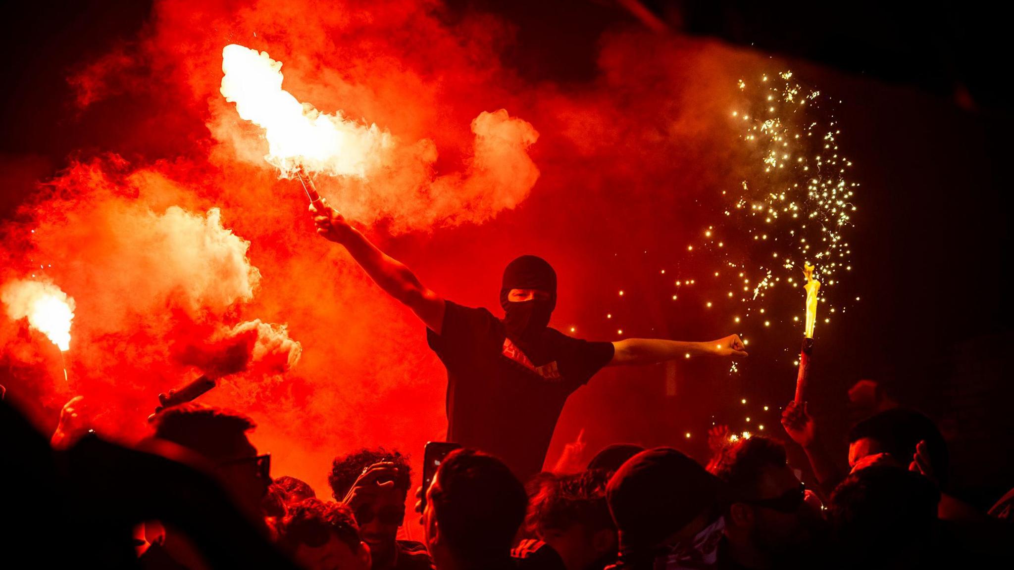 Arsenal fans part of the "Ashburton Army" light flares inside 'The Tunnel' outside the stadium prior to the UEFA Champions League 2024/25 Semi Final First Leg match between Arsenal FC and Paris Saint-Germain at Emirates Stadium in London, England