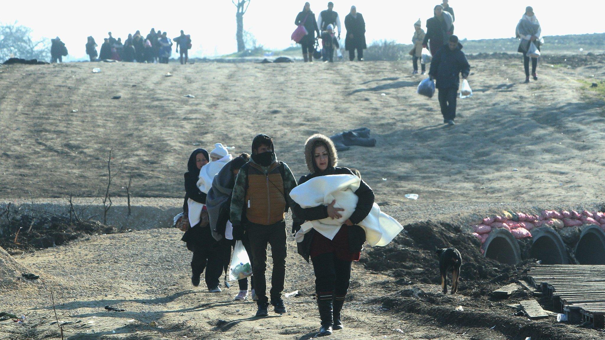 Migrants from Syria, Iraq and Afghanistan travelling on foot from Macedonia to a camp on the Serbia/Macedonia border