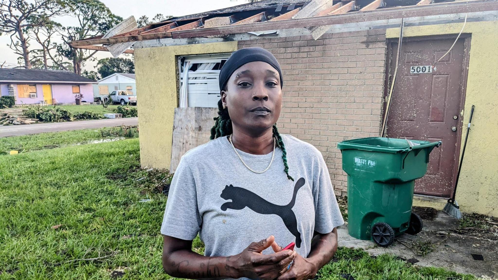 Crystal Coleman stands in front of the ruins of her home in south Florida 