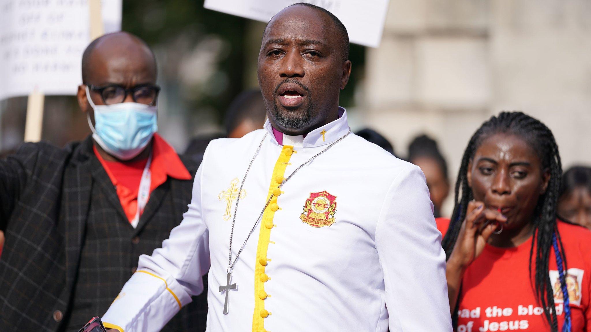 Bishop Climate Wiseman, 46, is greeted by his supporters outside Inner London Crown Court,