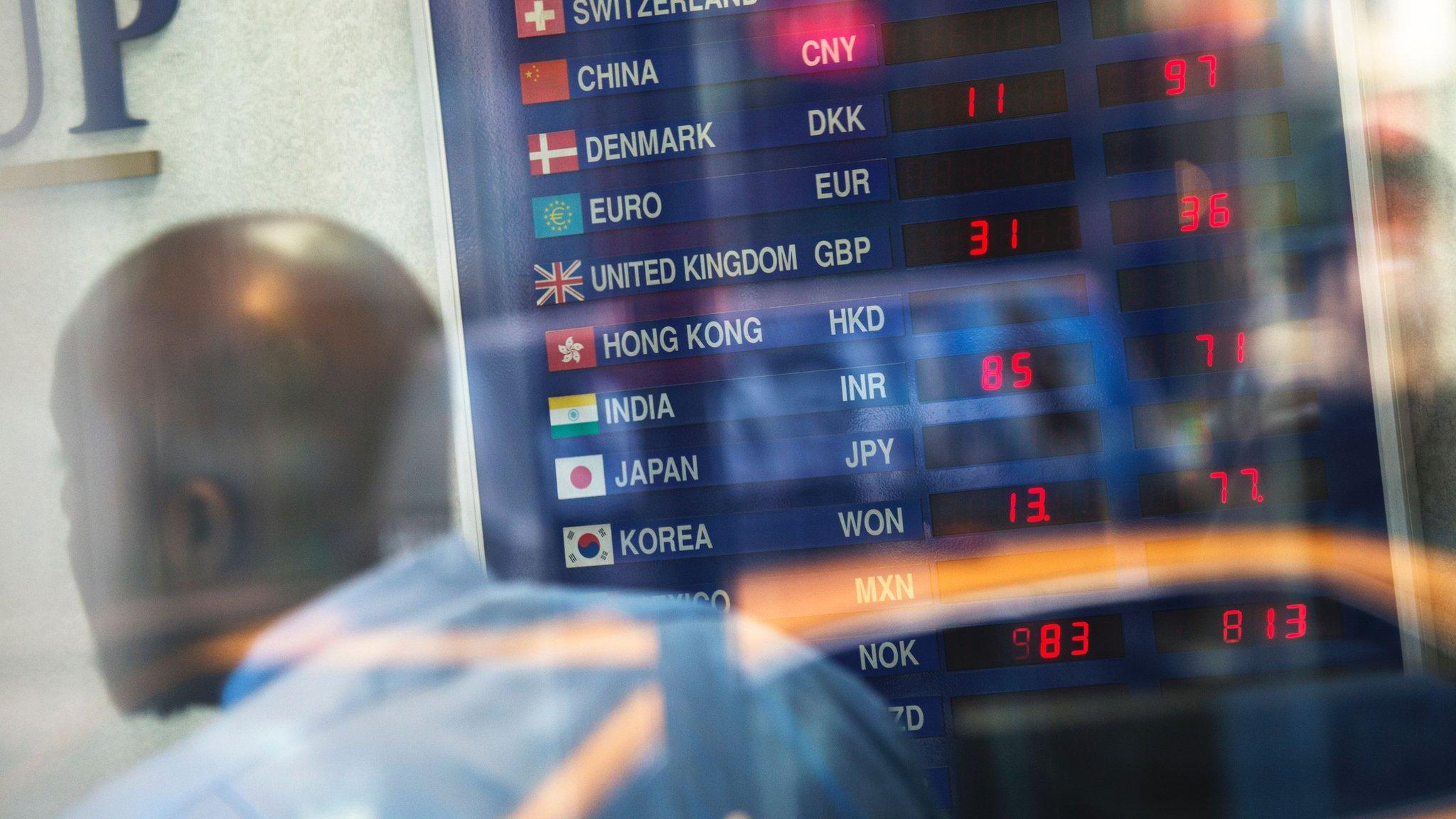 A man looks at global rates at a currency exchange shop in Times Square on June 24, 2016 in New York