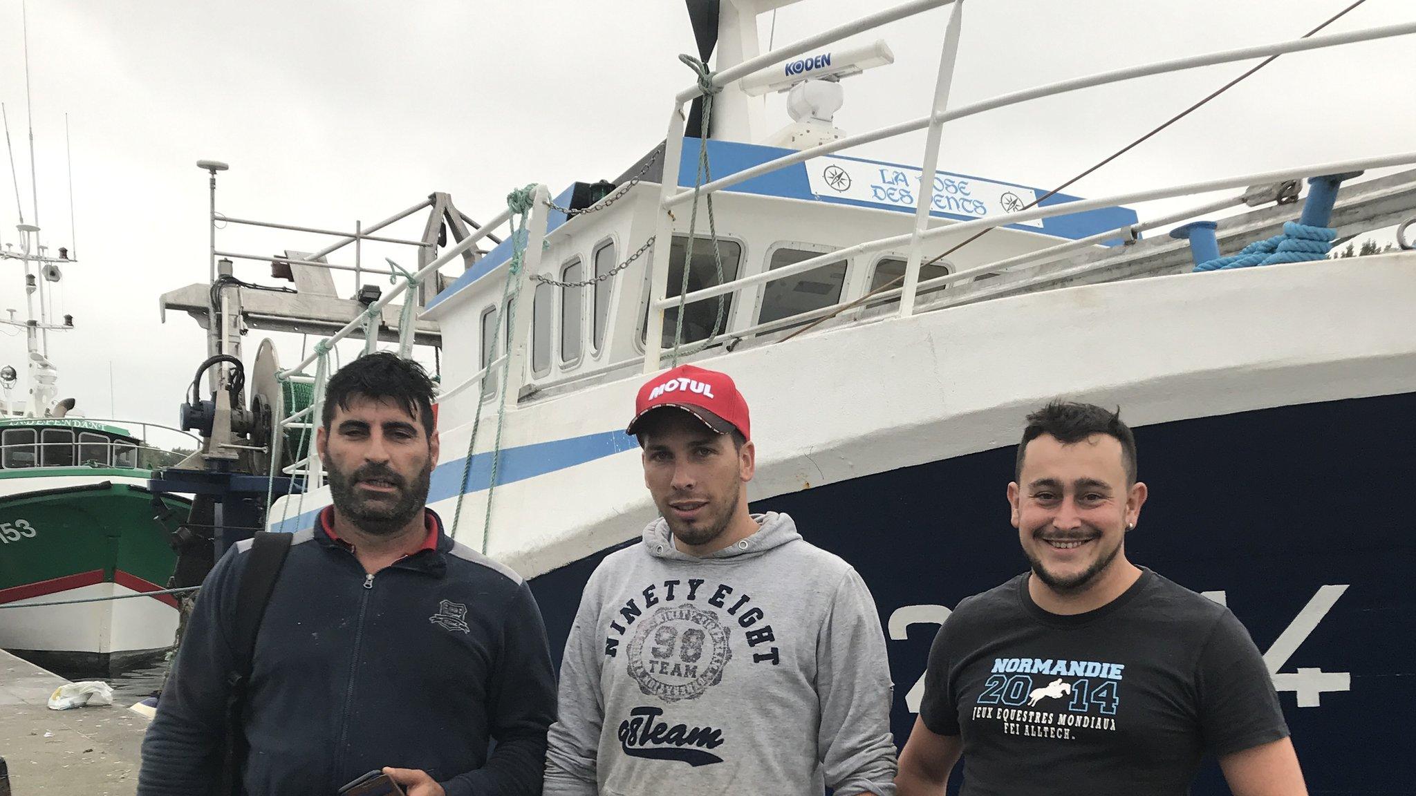 French scallop fishermen pictured next to La Rose Des Vents, a fishing boat