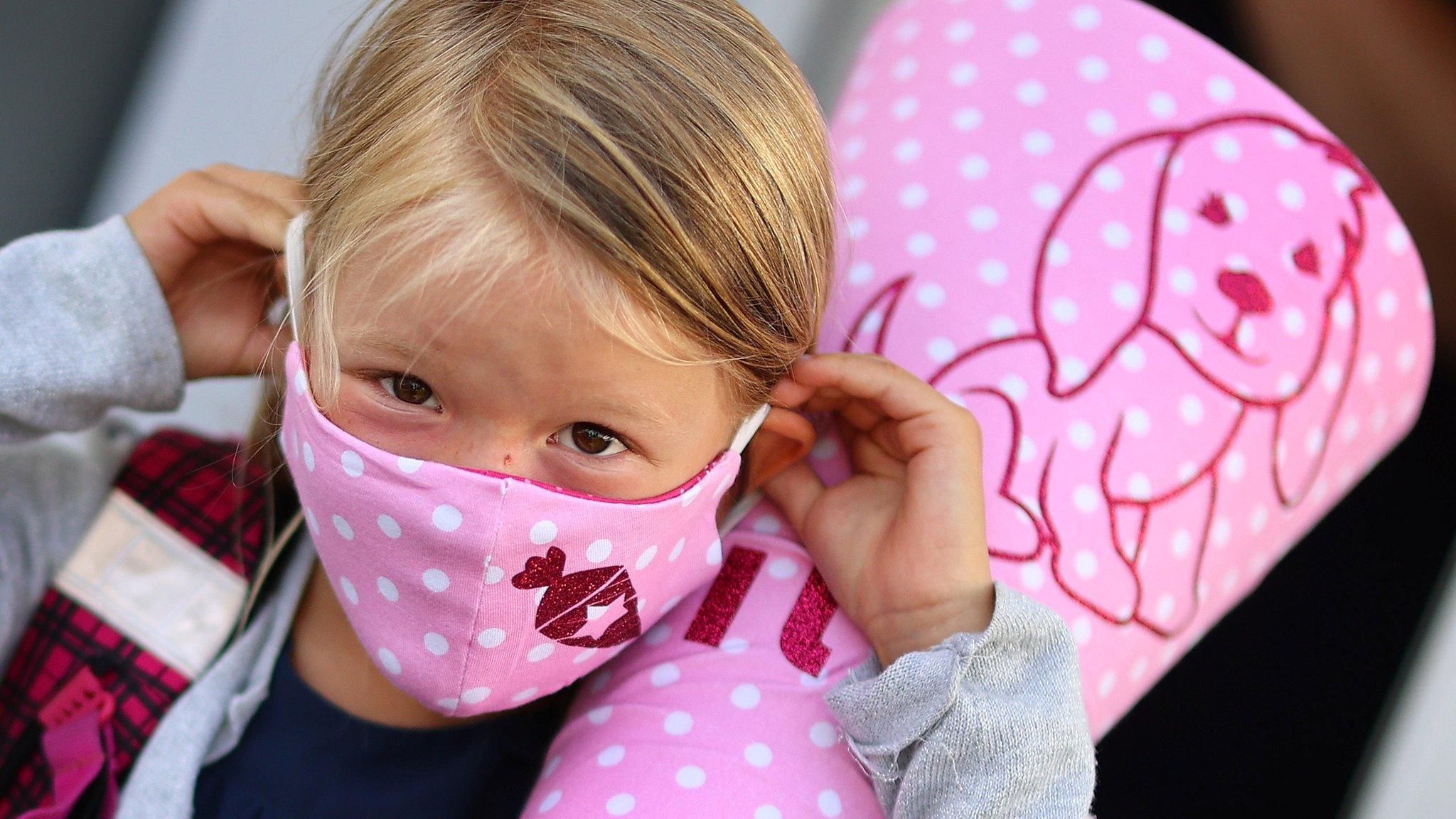 A six-year-old schoolgirl on her way to school in a facemask in Germany