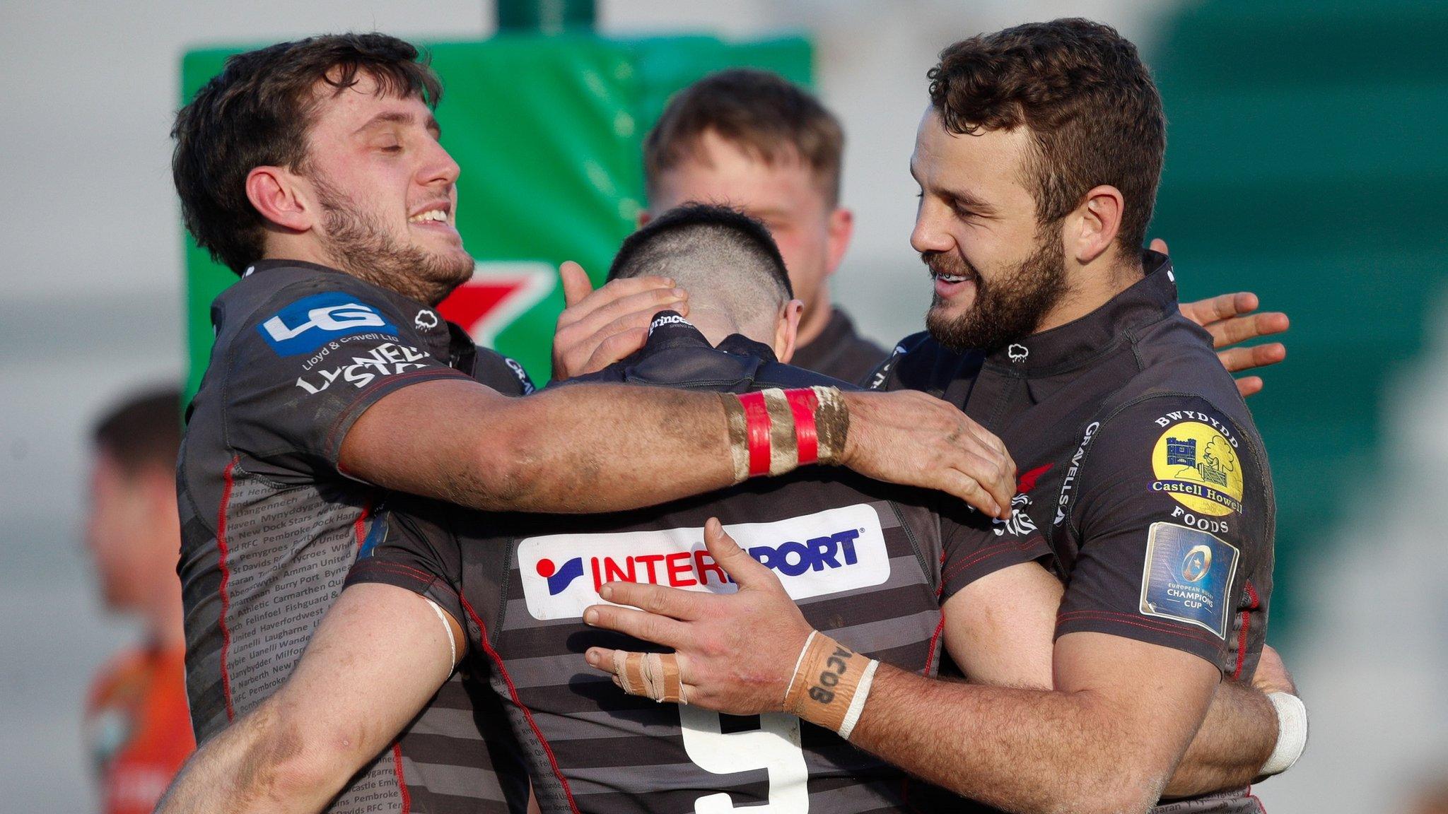 Scarlets players gather around try-scorer Gareth Davies in Treviso