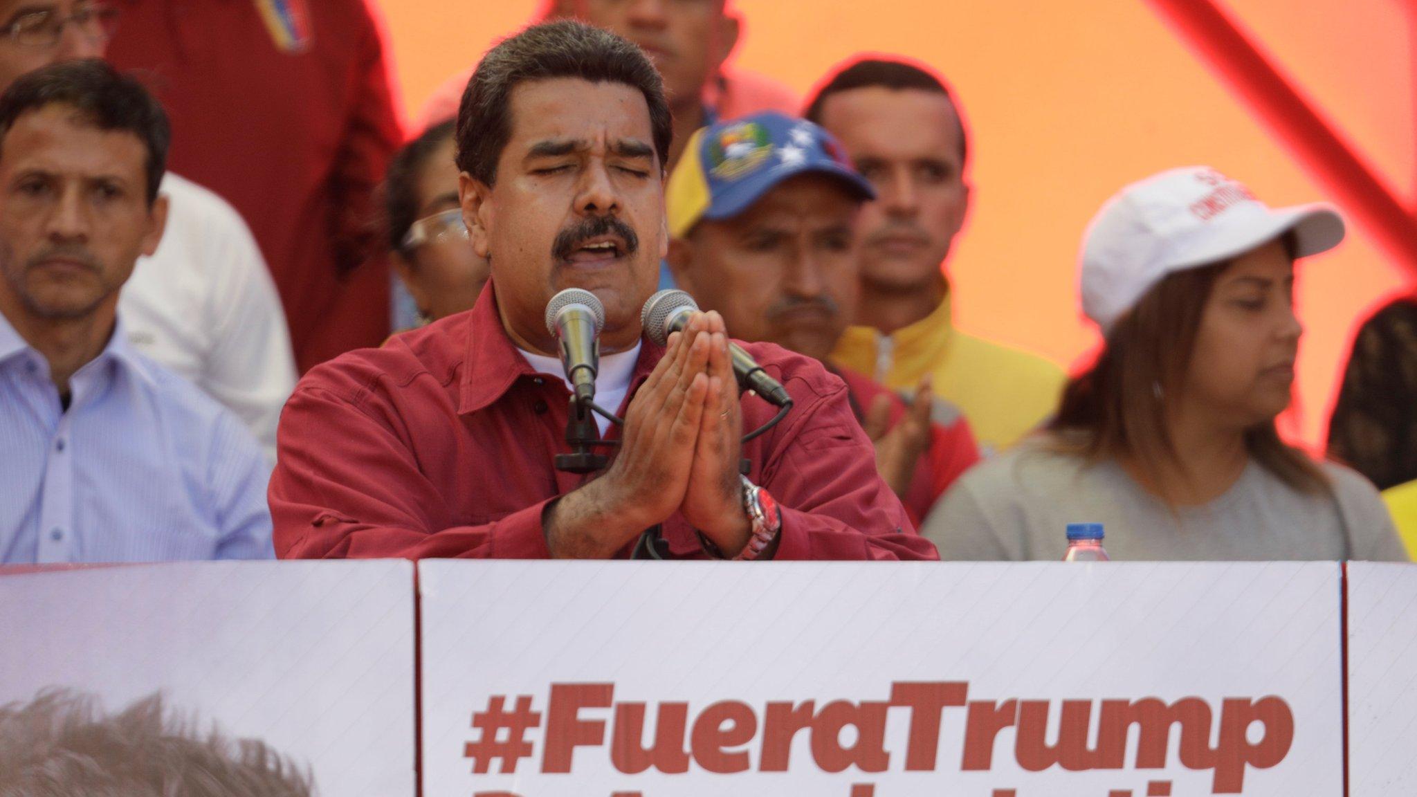 President Nicolas Maduro gives a speech by a sign reading, "Trump go away from Latin America" at a rally against President Donald Trump in Caracas, Venezuela, August 14, 2017