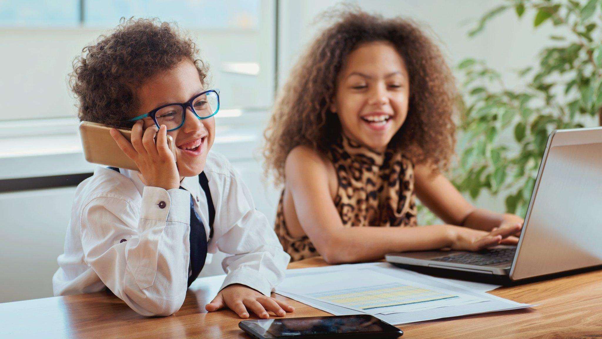 two-children-at-a-desk-laughing-and-working