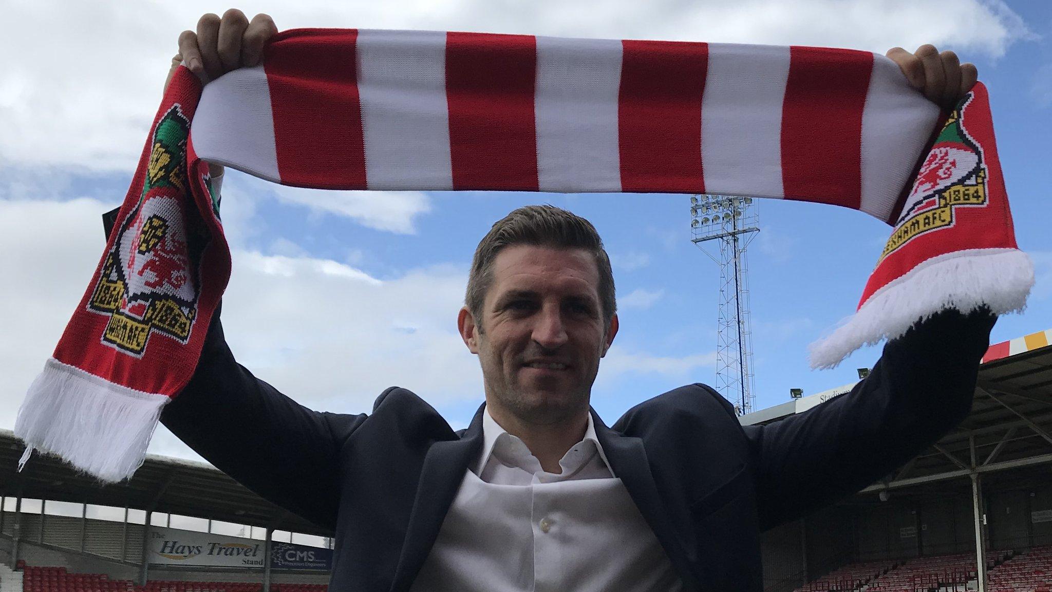 Sam Ricketts holds a Wrexham scarf high