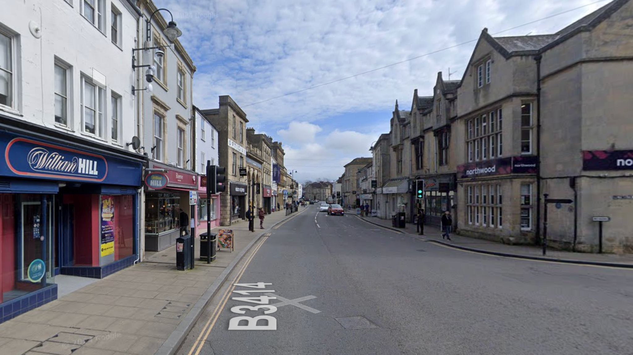 The Market Place in Warminster, Wiltshire. William Hill betting shop can be seen on the left. more buildings can be seen further down the road.