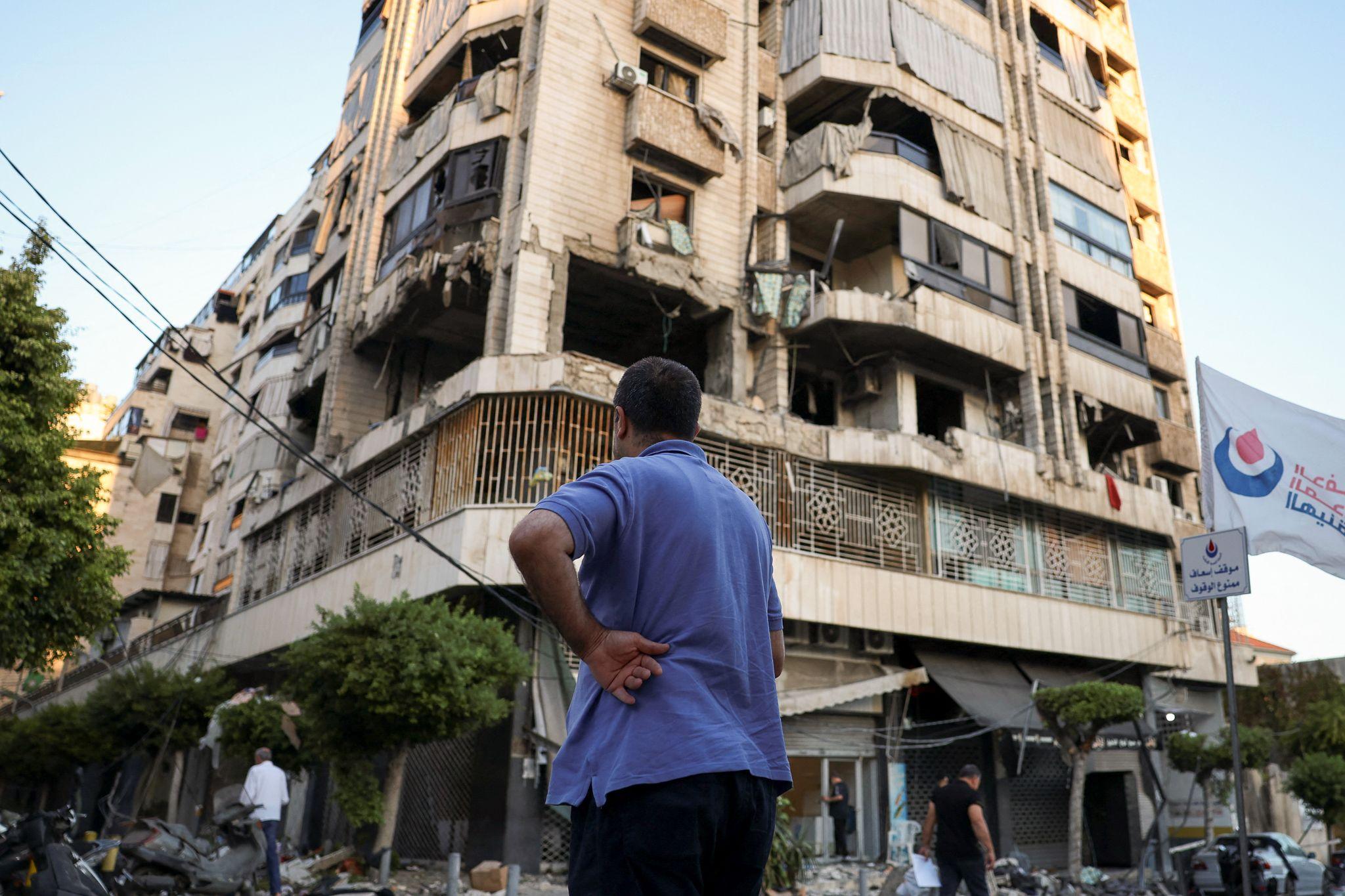 A Beirut resident stands in front of a building damaged in an Israeli air strike last week.