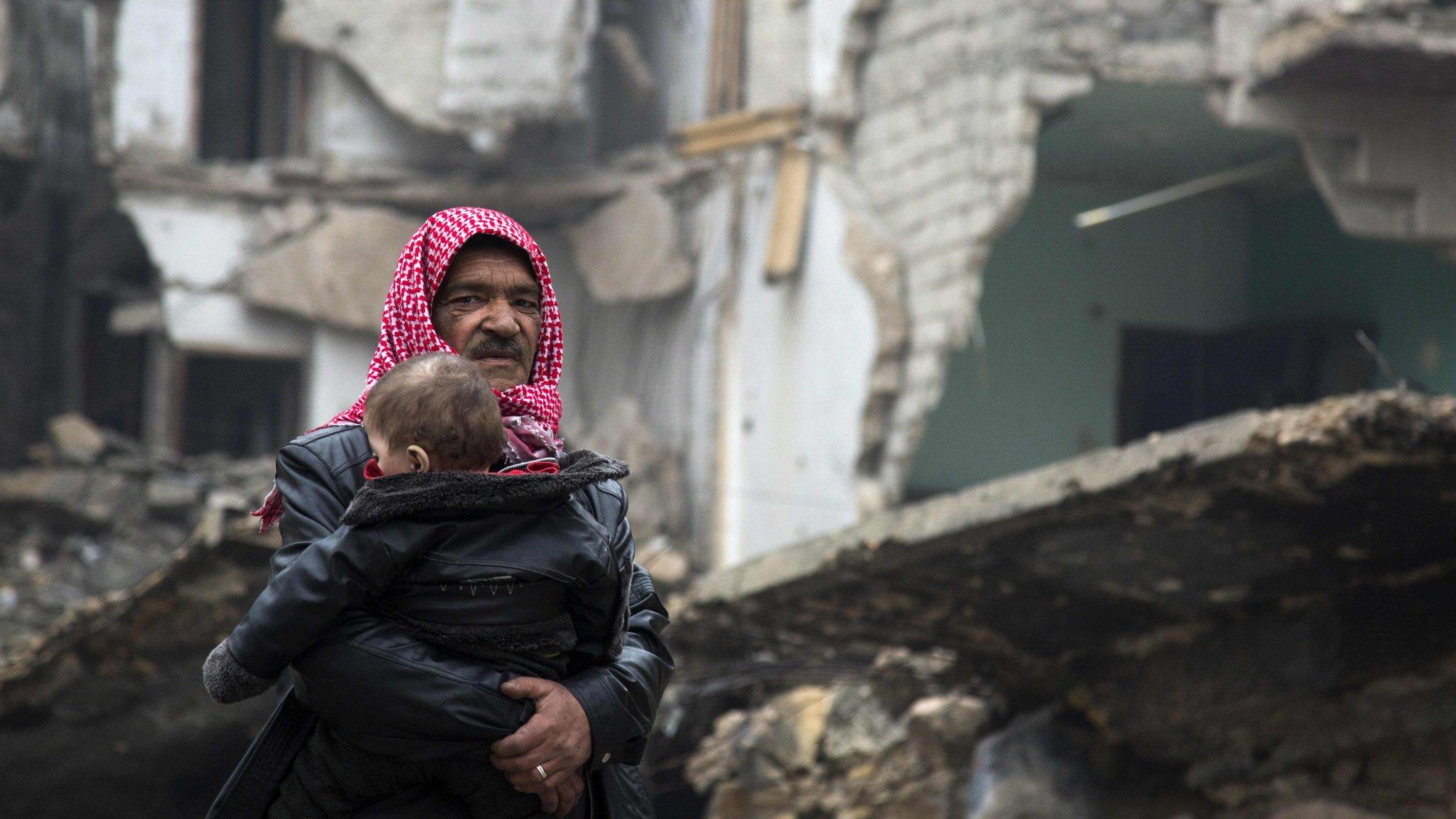 Man carries child as he leaves rebel-held area for government territory - 13 December