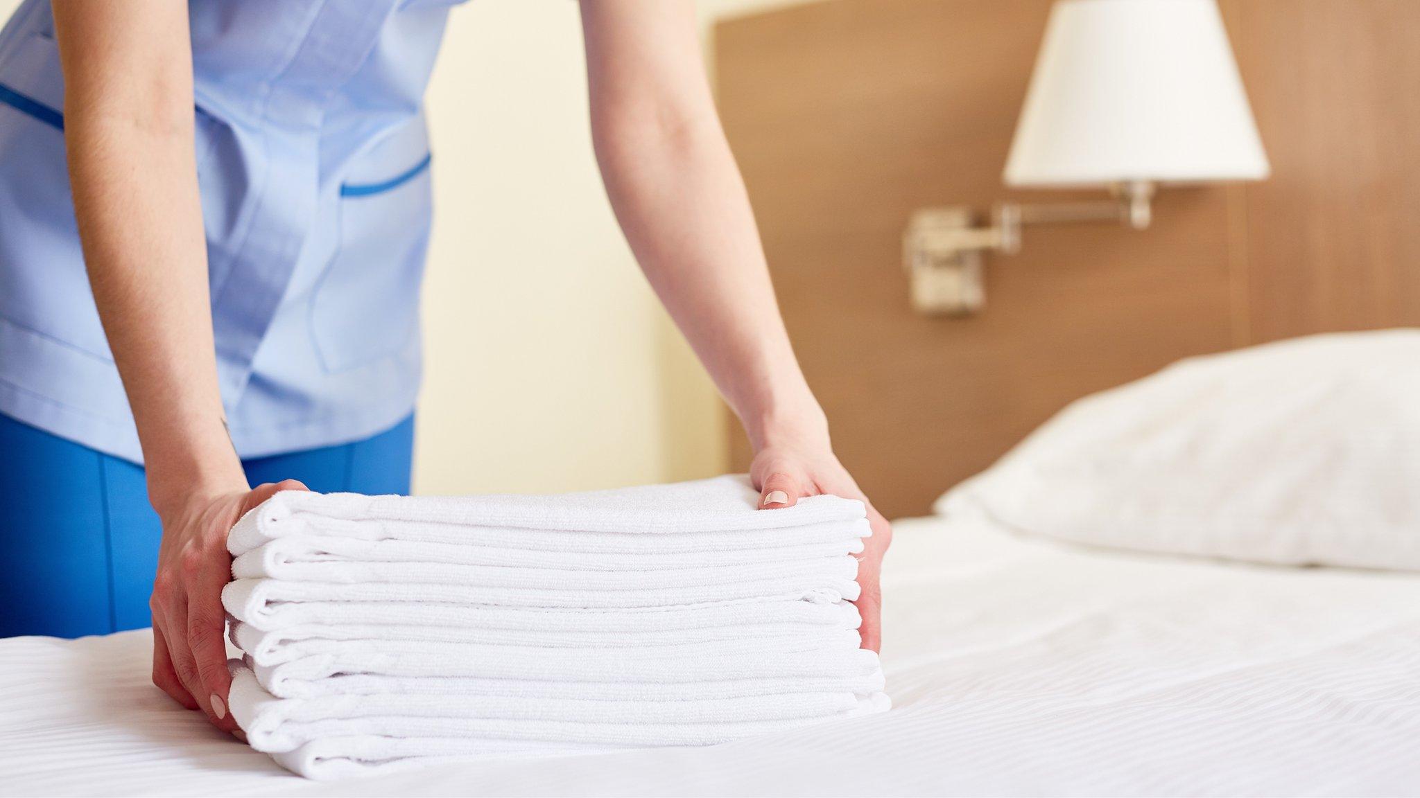 Hotel worker in hotel bedroom