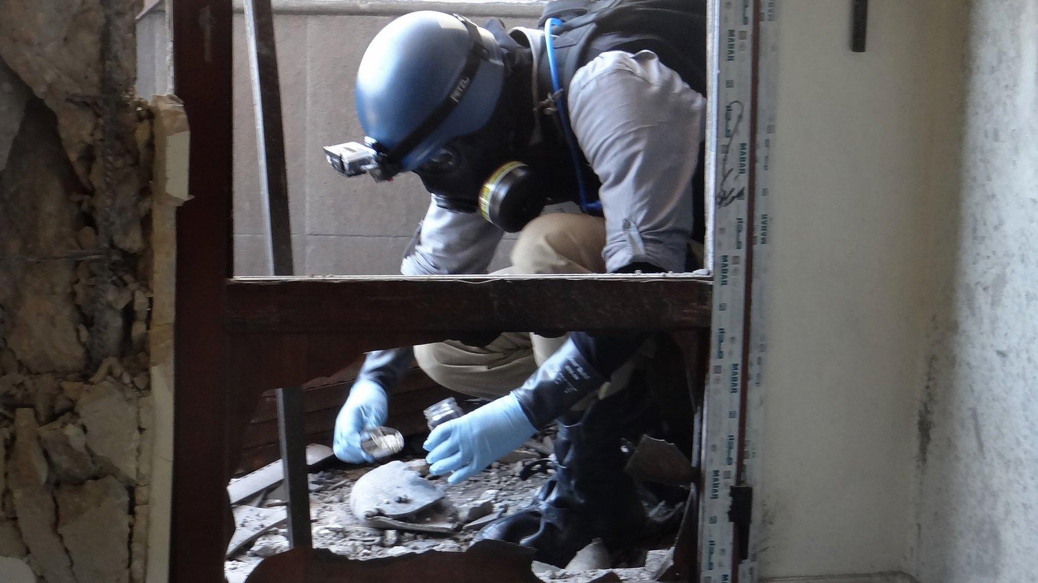 A UN expert collects samples at a site where rockets filled with Sarin hit a suburb of Damascus, Syria (29 August 2013)