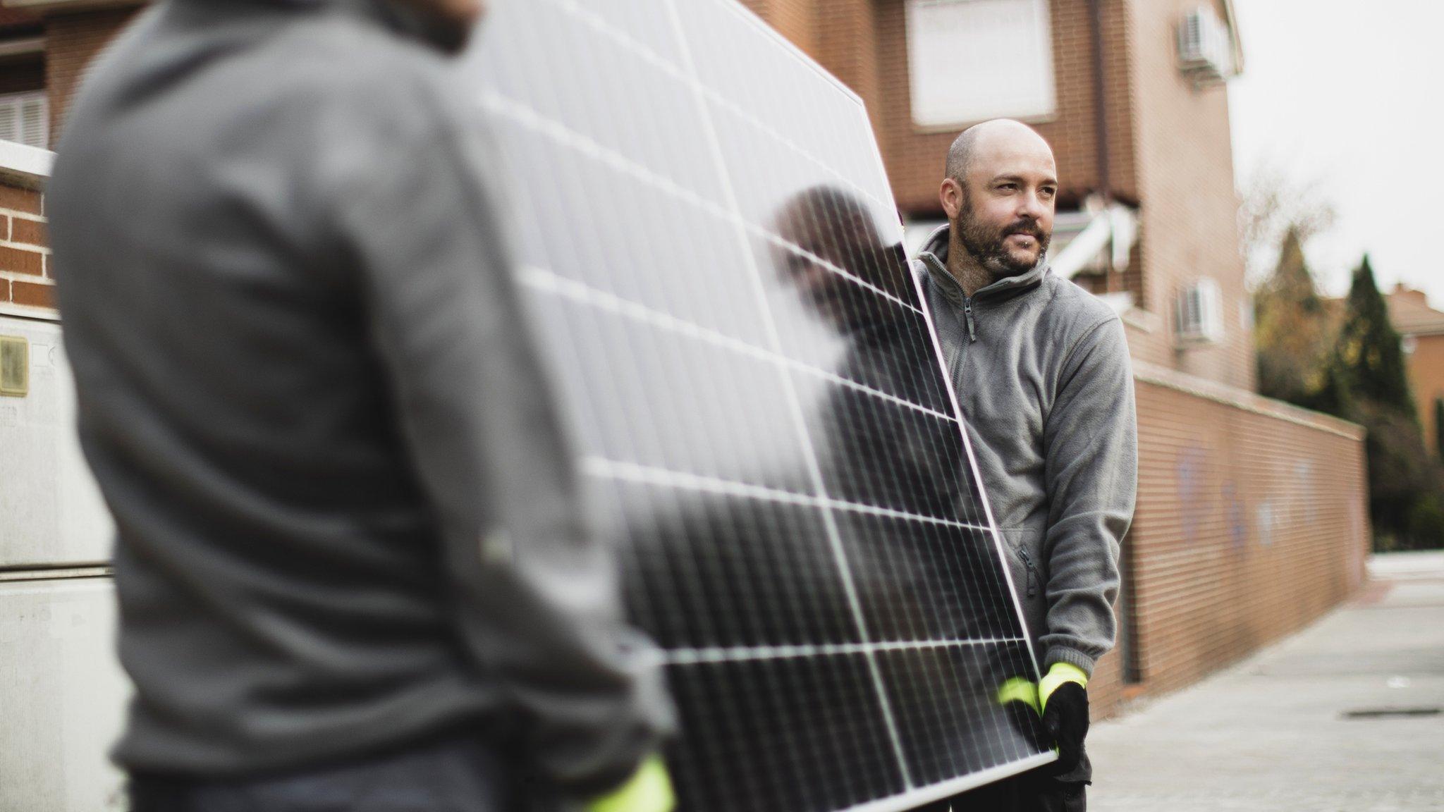 Workers moving a solar panel