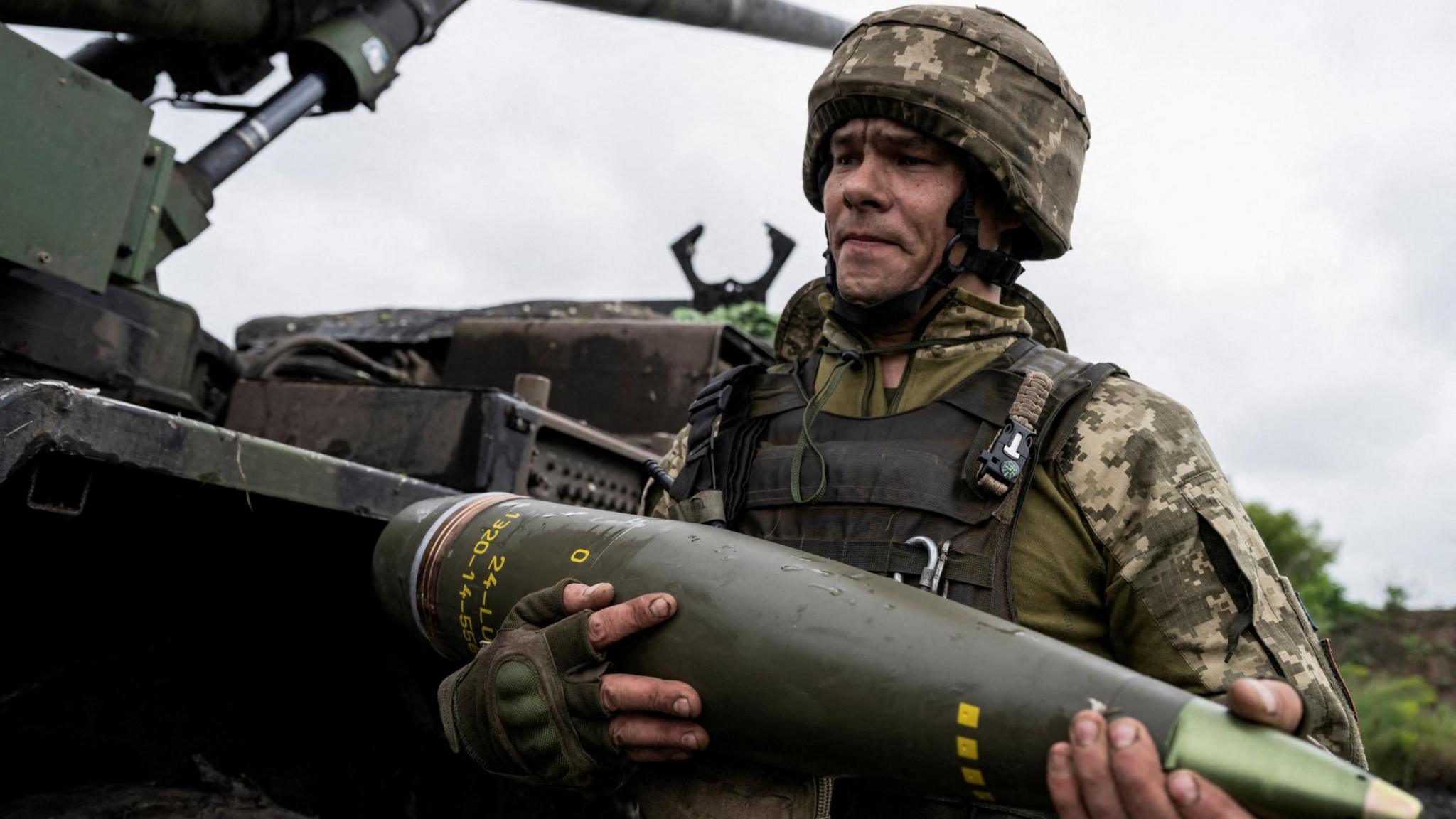 Ukrainian soldier carrying artillery shell