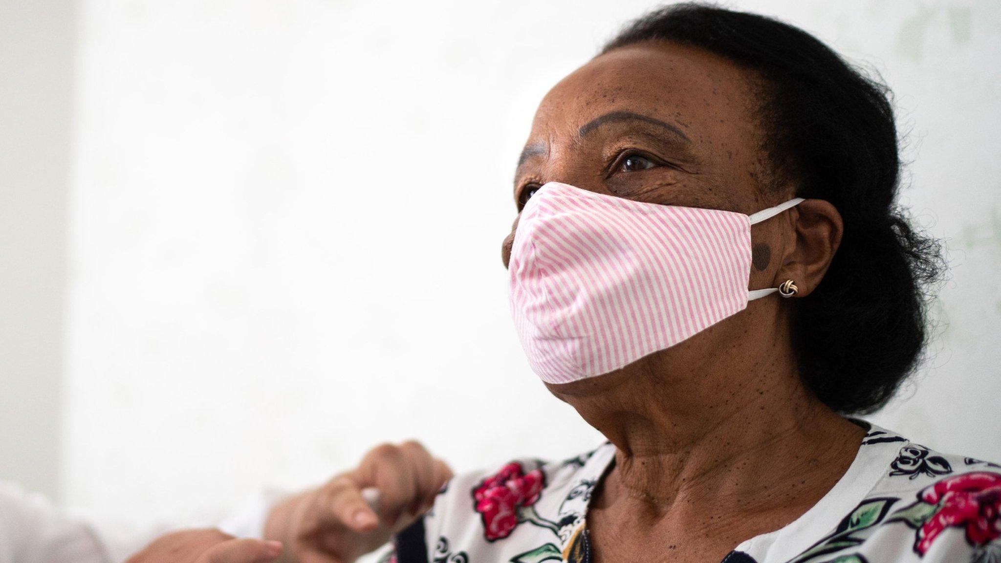 A black woman receiving a jab in her arm.