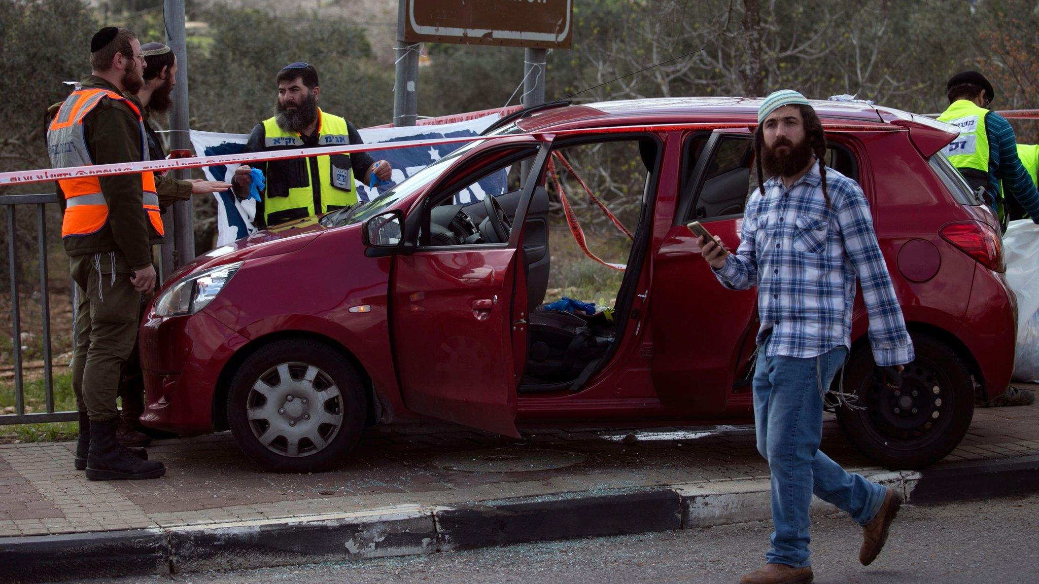 Israeli forensic specialists inspect a a car at the site of a deadly attack near the Jewish settlement of Ariel in the occupied West Bank (17 March 2019)