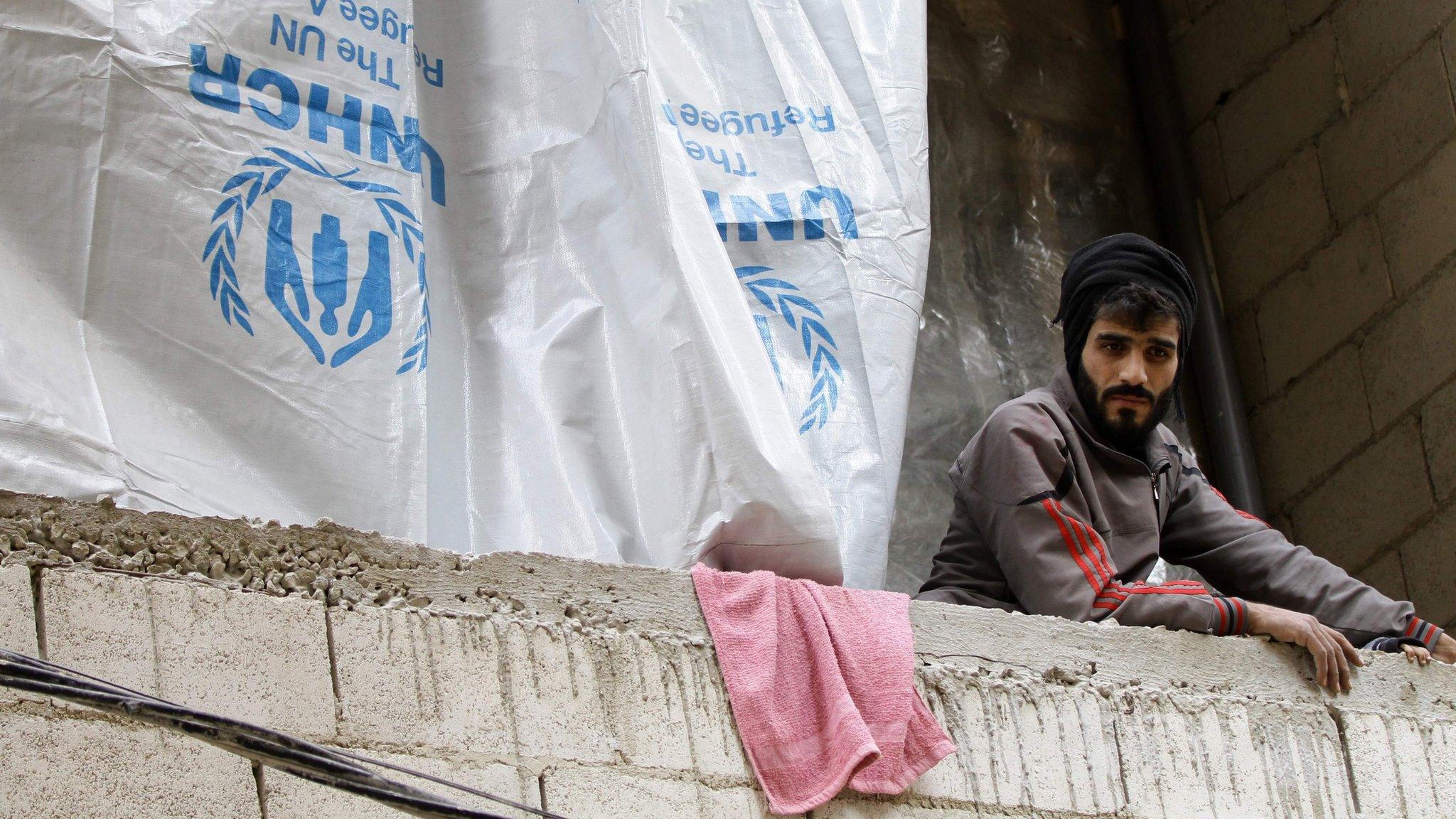 A Syrian man looks down from an unfinished building where he lives with his family in the Daf al-Sakhr area of Jaramana, on the outskirts of the Syrian capital Damascus (16 December 2015)