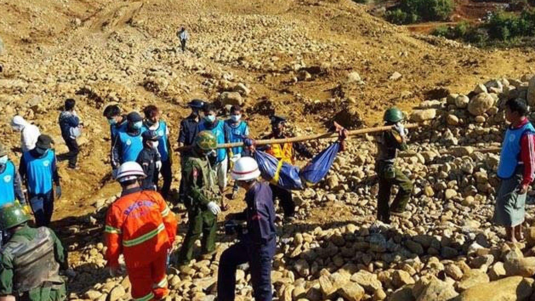 Soldiers carry the bodies of miners killed by a landslide in a jade mining area in Hpakhant, in Myanmar"s Kachin state on 22 November 2015