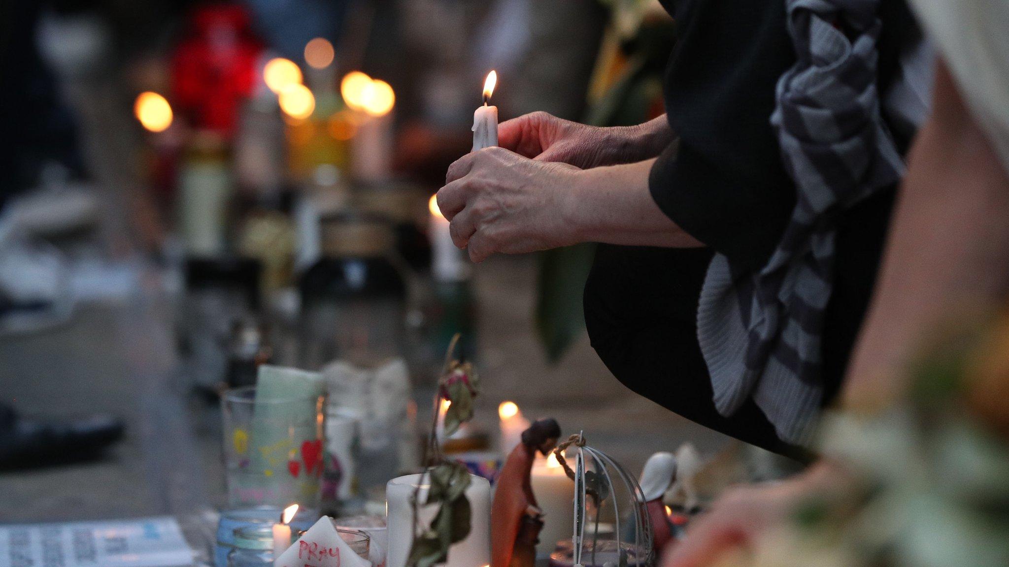 A candle being laid at a tribute