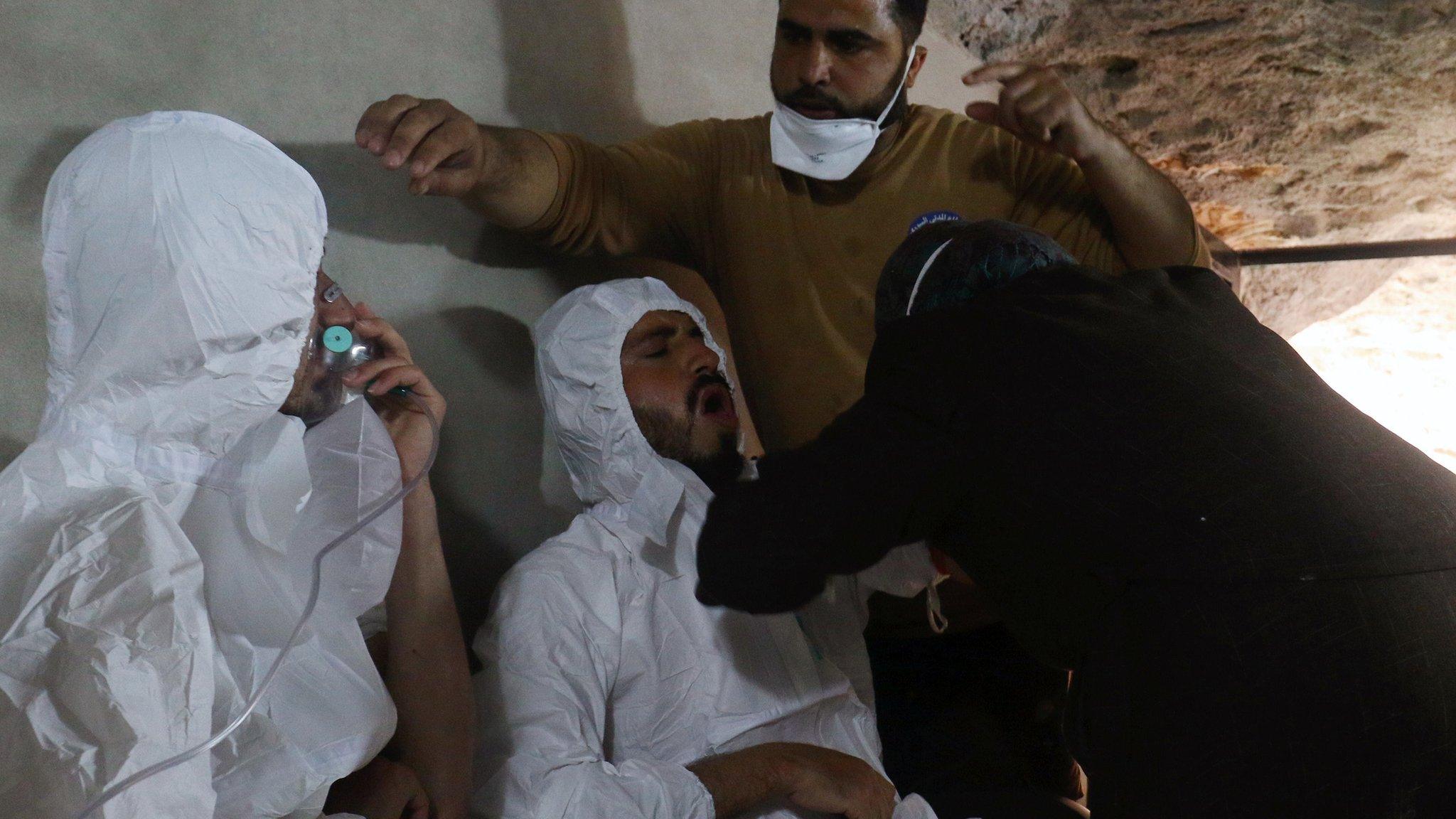 A man breathes through an oxygen mask as another one receives treatment after what rescue workers described as a suspected chemical attack in the town of Khan Sheikhoun in rebel-held Idlib province, Syria (4 April 2017)