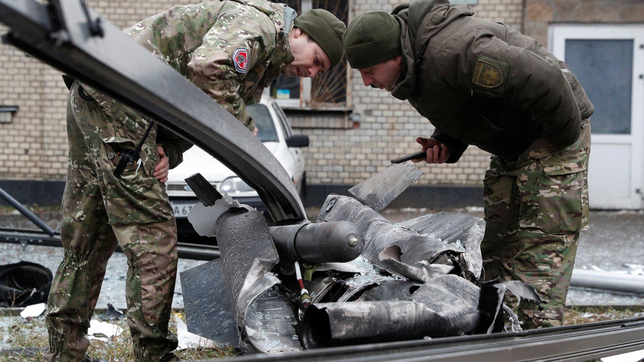 Police officers inspect the remains of a missile that fell in the street, after Russian President Vladimir Putin authorized a military operation in eastern Ukraine, in Kyiv, Ukraine February 24, 2022