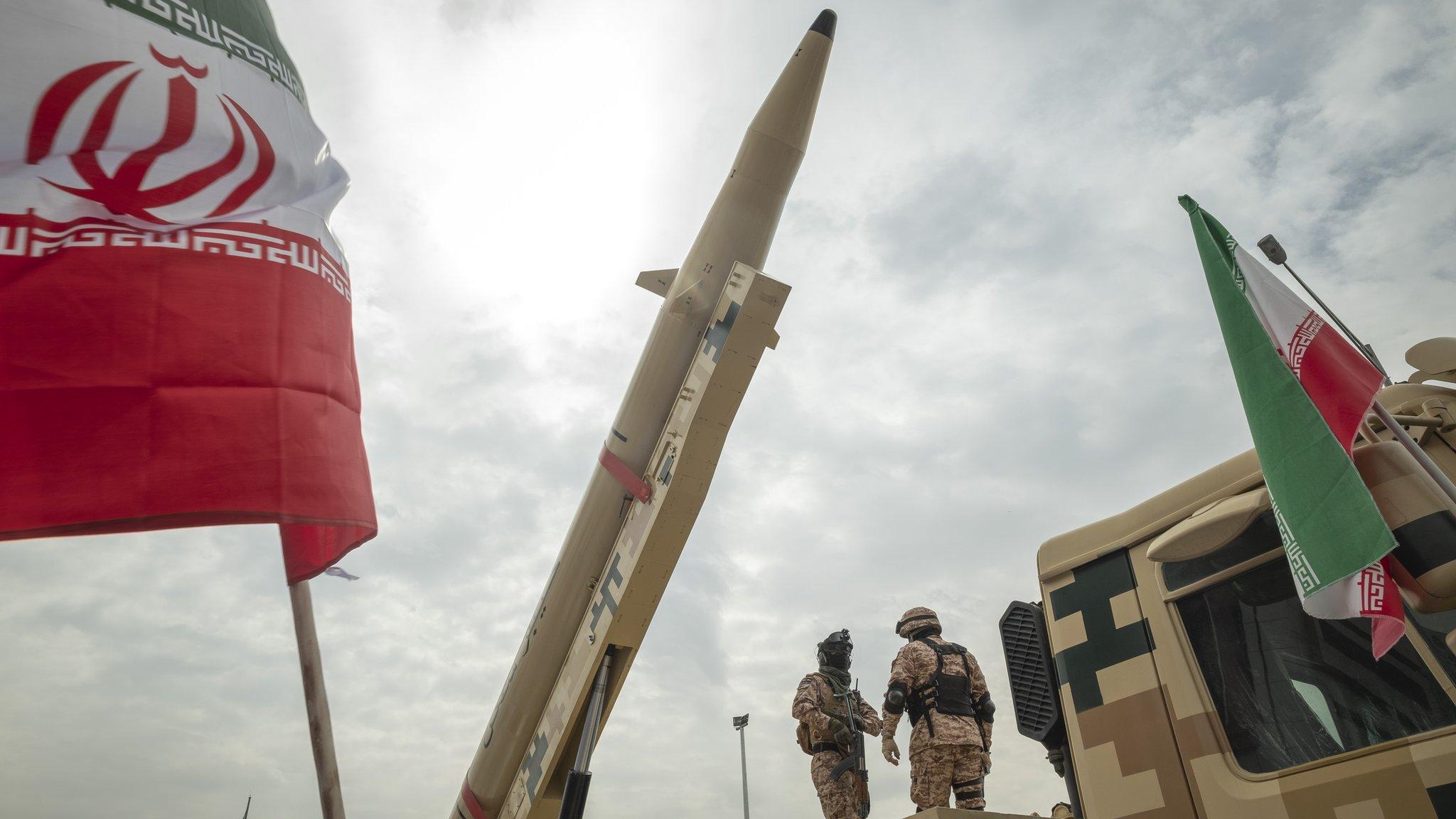 File photo showing members of Iran's Islamic Revolution Guard Corps (IRGC) standing next to a Kheibar Shekan (Castle Buster) ballistic missile during a rally in Tehran, Iran, on 29 April 2022