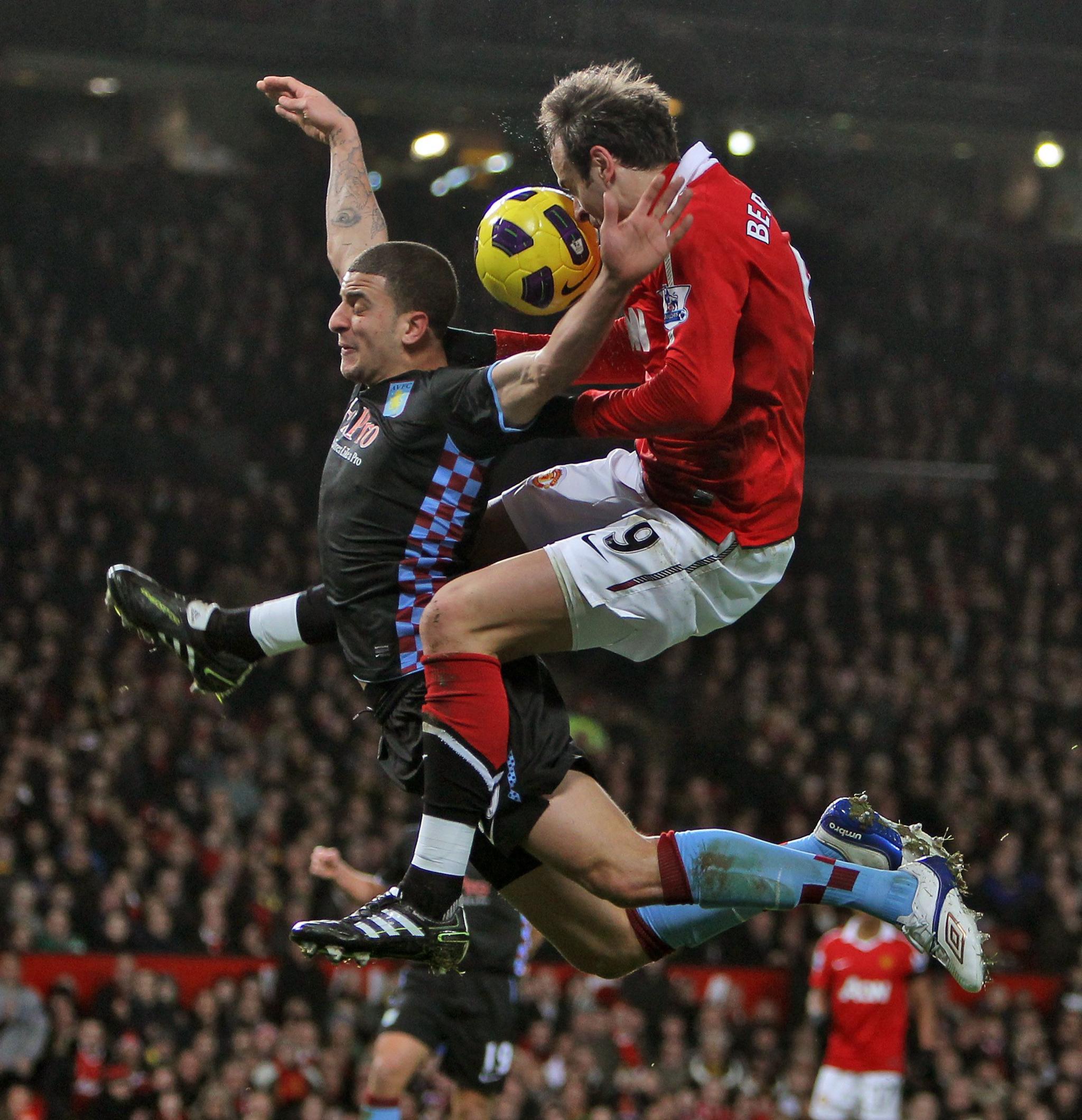 Kyle Walker in the air with Dimitar Berbatov challenging for the ball