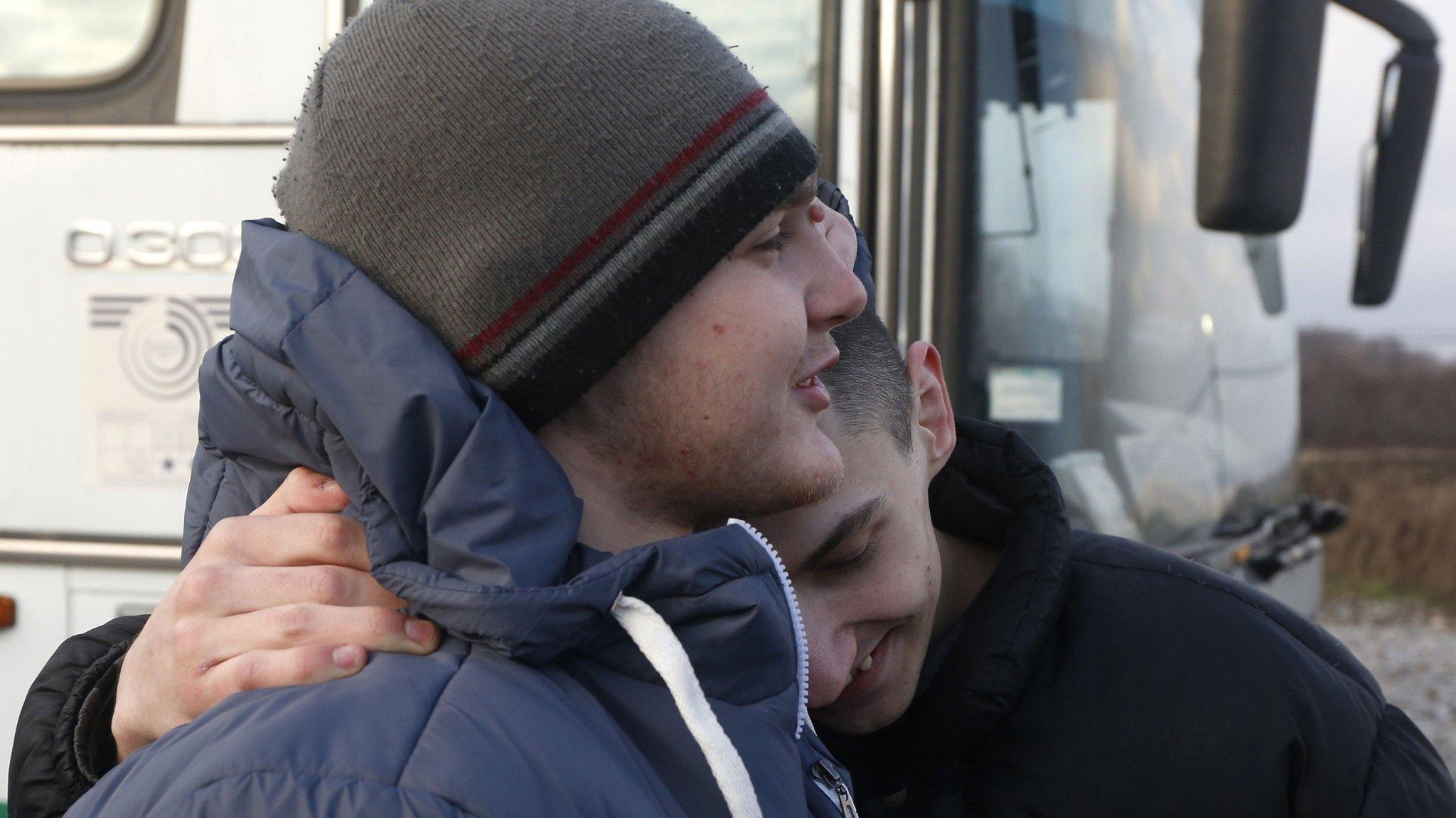 Ukrainian prisoners hug each other during a prisoner exchange in eastern Ukraine