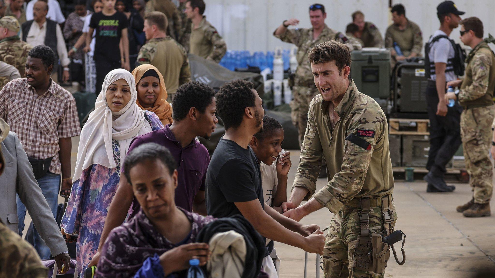 British military personnel help Britain nationals board flights at Wadi Seidna Air Base in Khartoum, Sudan