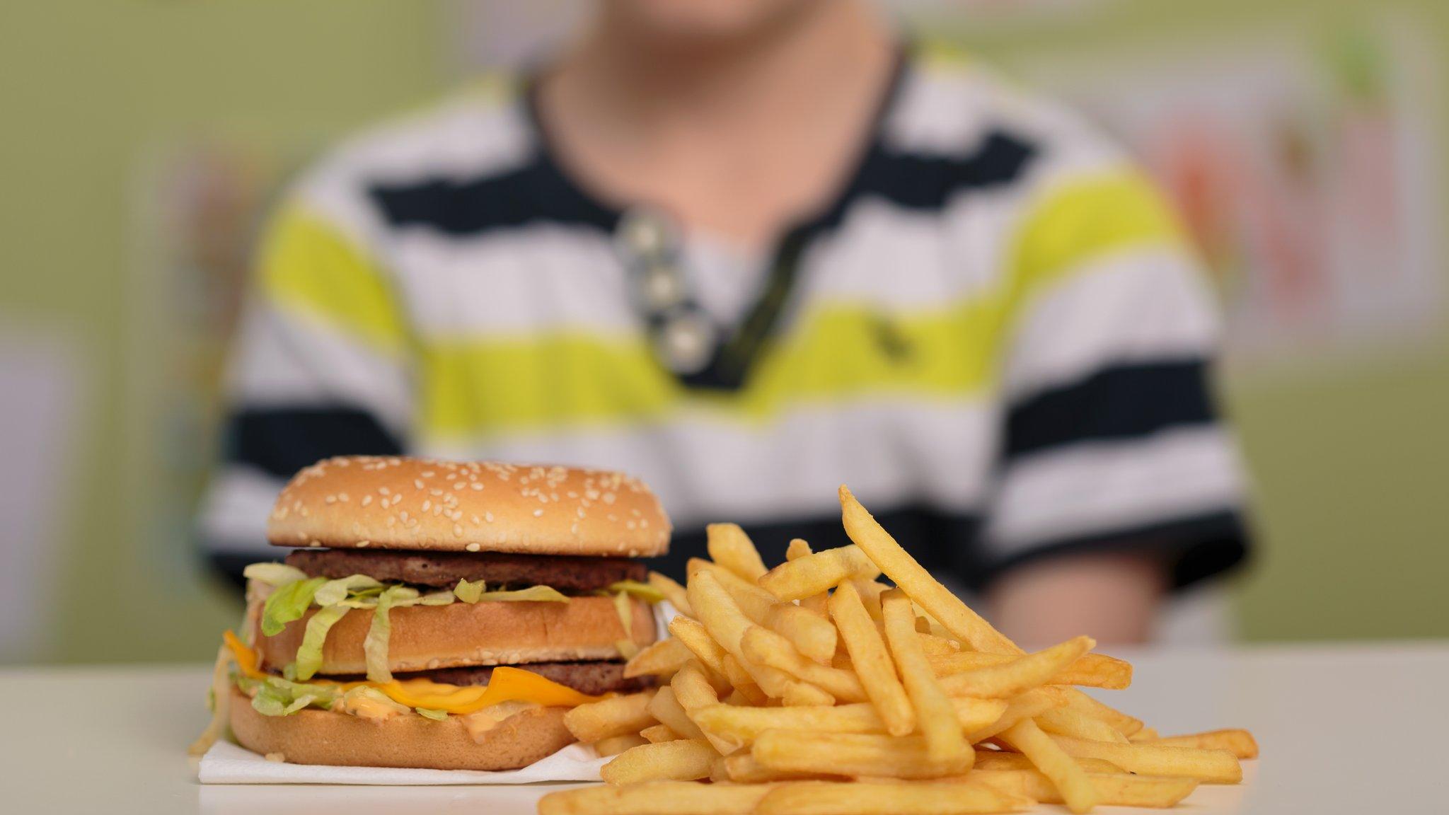 Schoolchild with burger and chips