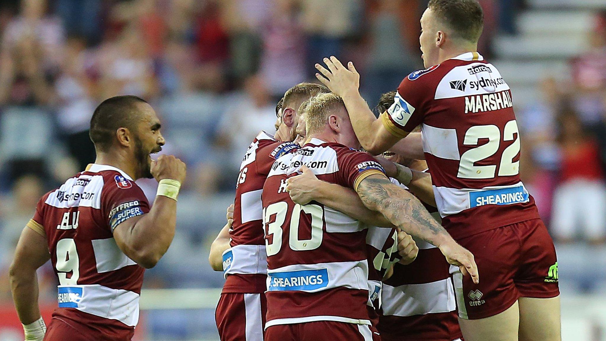 Josh Woods is swamped by team-mates after his winning drop-goal for Wigan