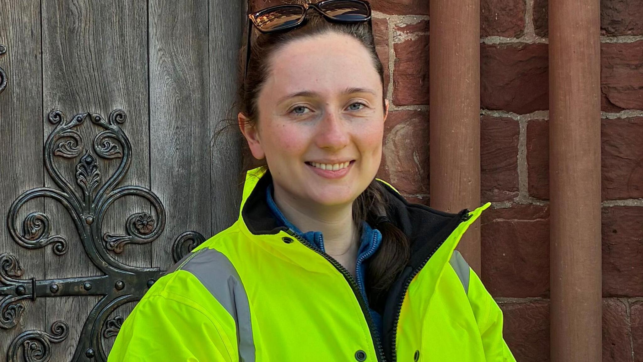 With two days of training under her belt, the OIC Head stands in front of a church door in hi-vis clothing