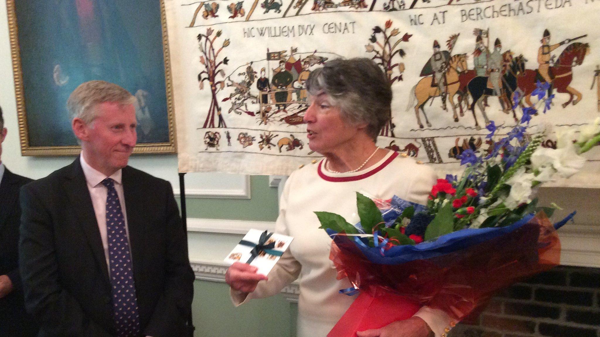 Vice Adm Sir Ian Corder presenting Kate Russell with her British Empire Medal in Alderney's Islands Hall