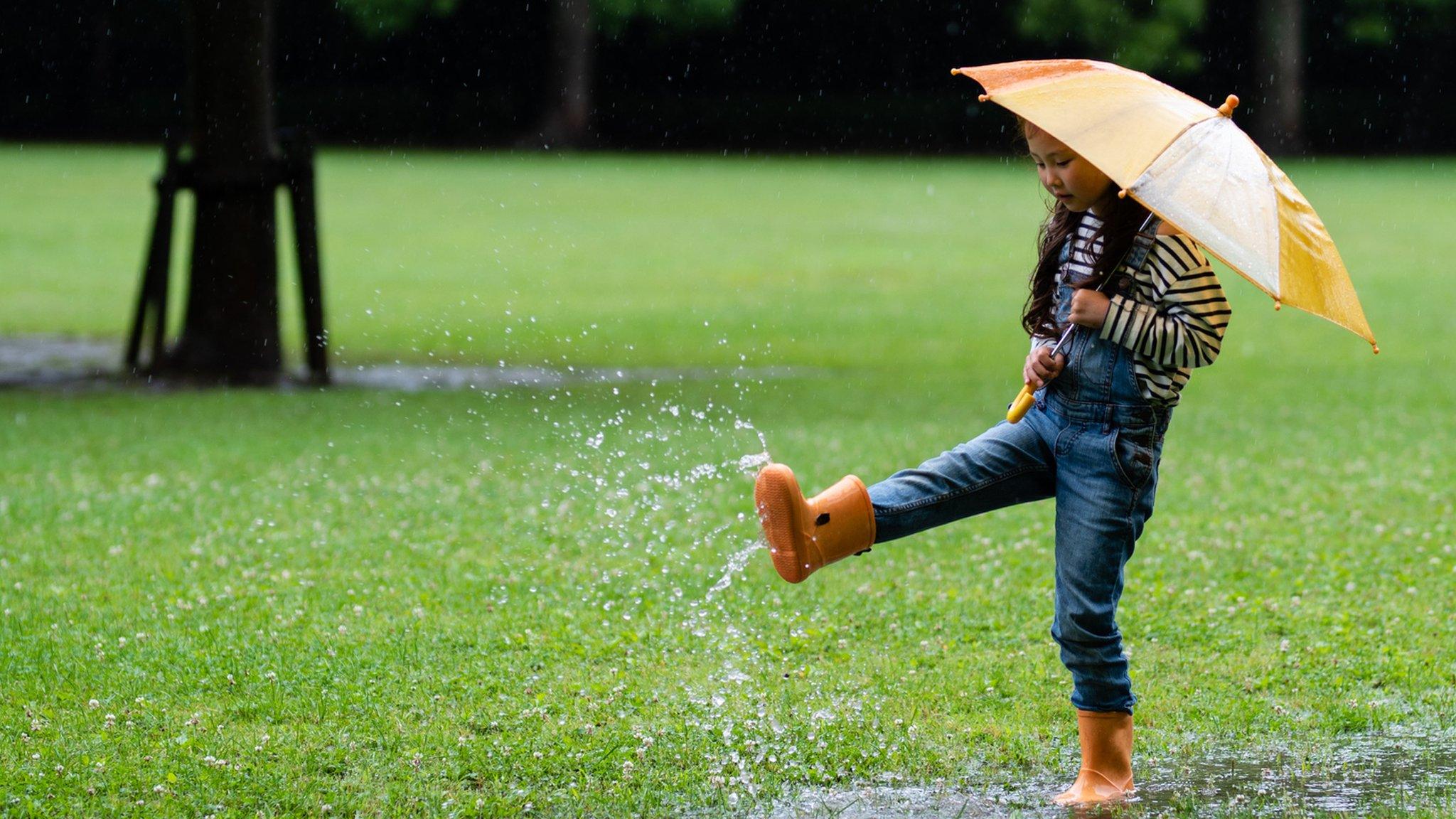 girl kicking puddles