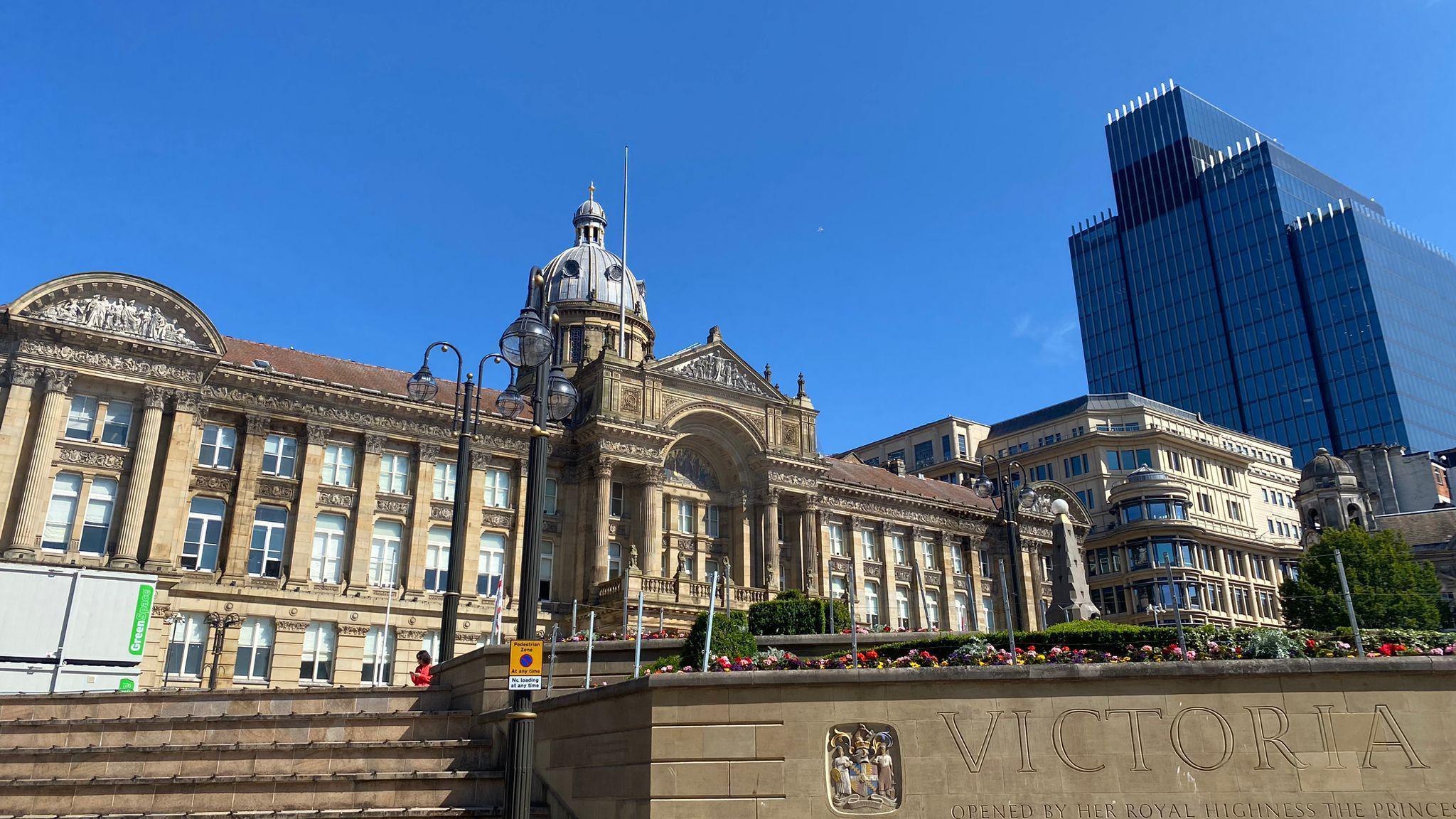 Birmingham City Council House in Victoria Square, with steps leading up to the building and a blue sky and a modern building in the background.