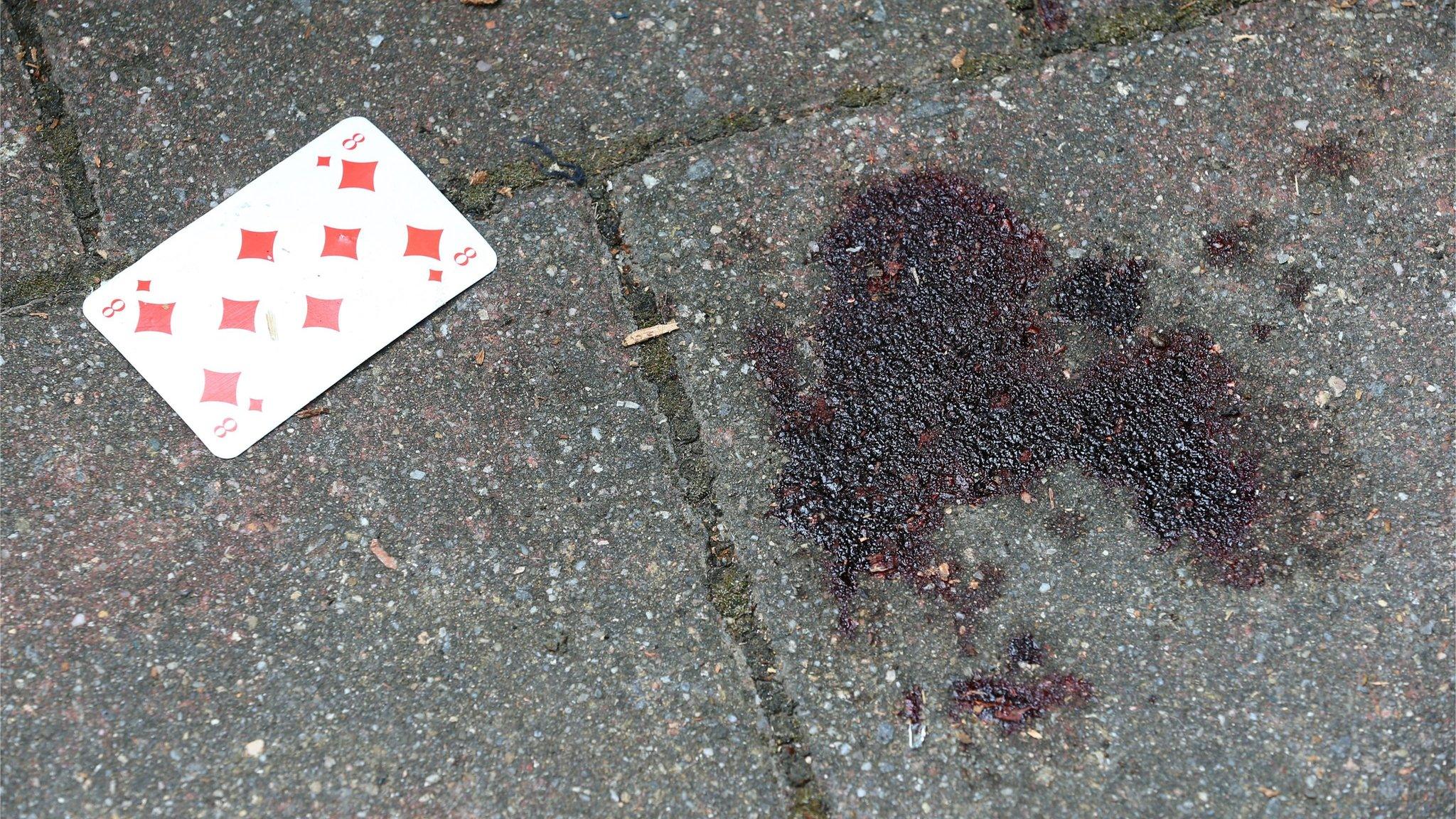 A blood stain on the floor next to a playing card at the crime scene in front of "Eugens Weinstube" in the Old Town one day after a bomb explosion in Ansbach, Germany, 25 July 2016