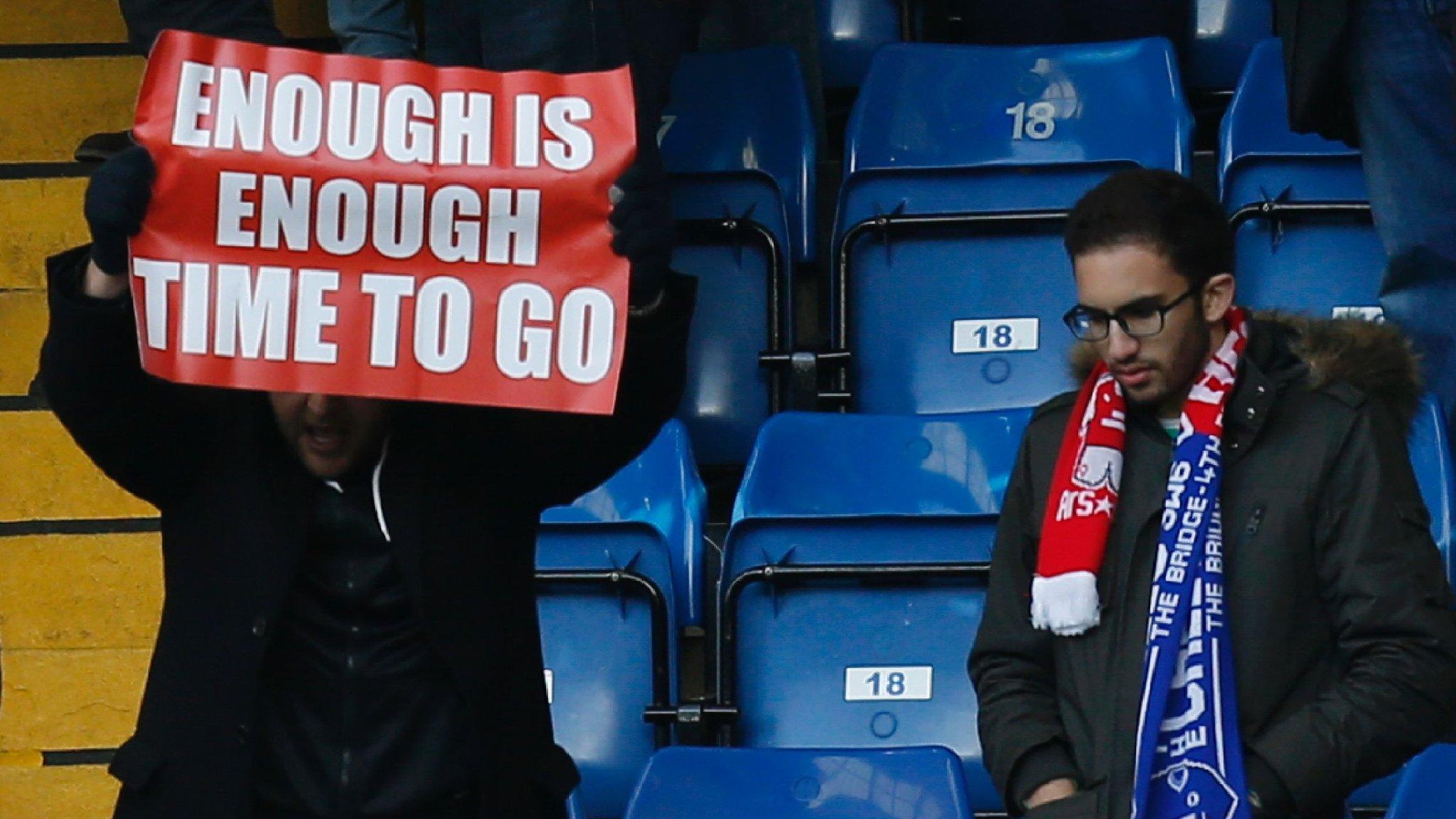 Arsenal fan holds banner at Stamford Bridge