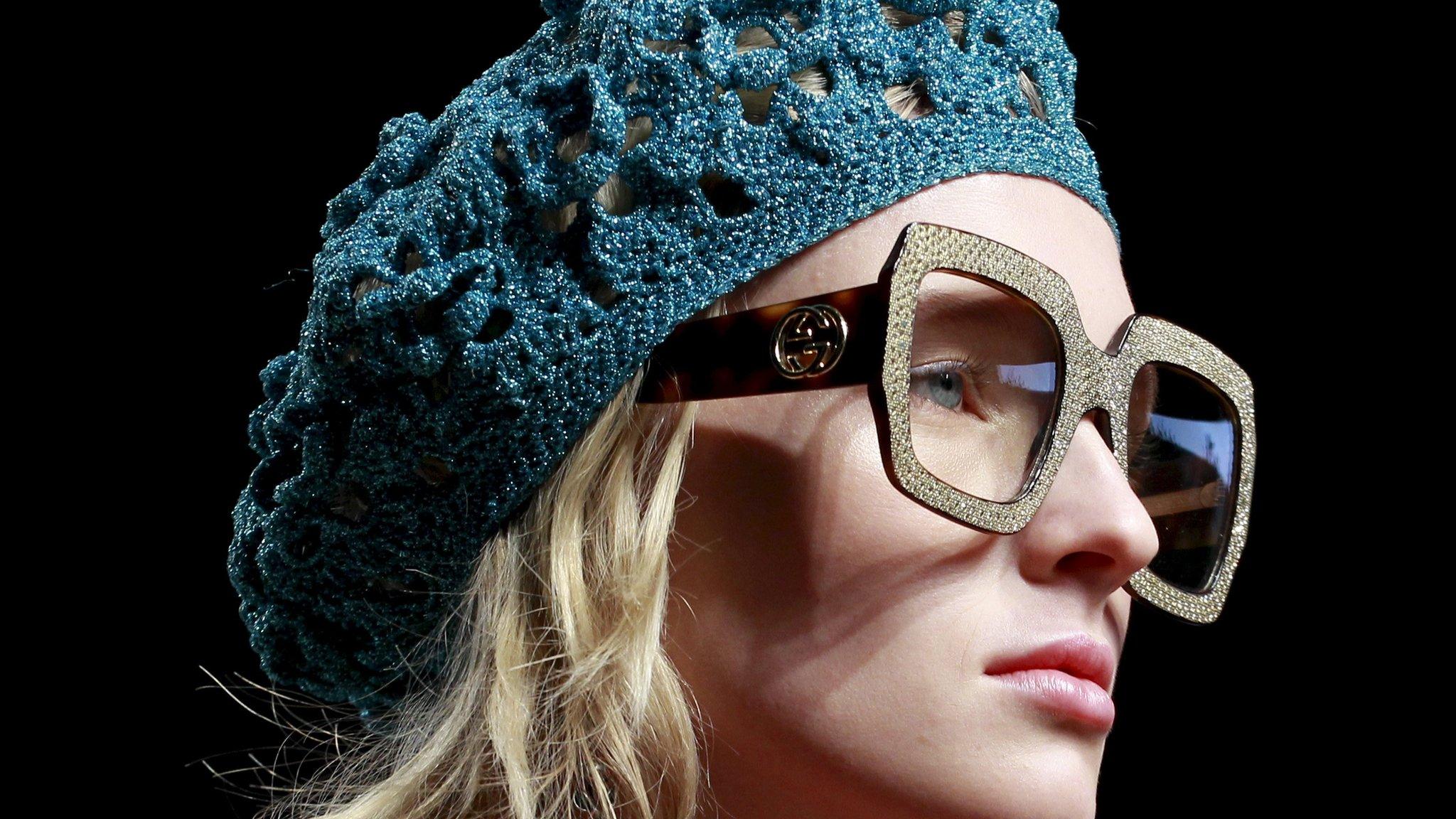 Gucci model's head - wearing large glasses and a woollen hat