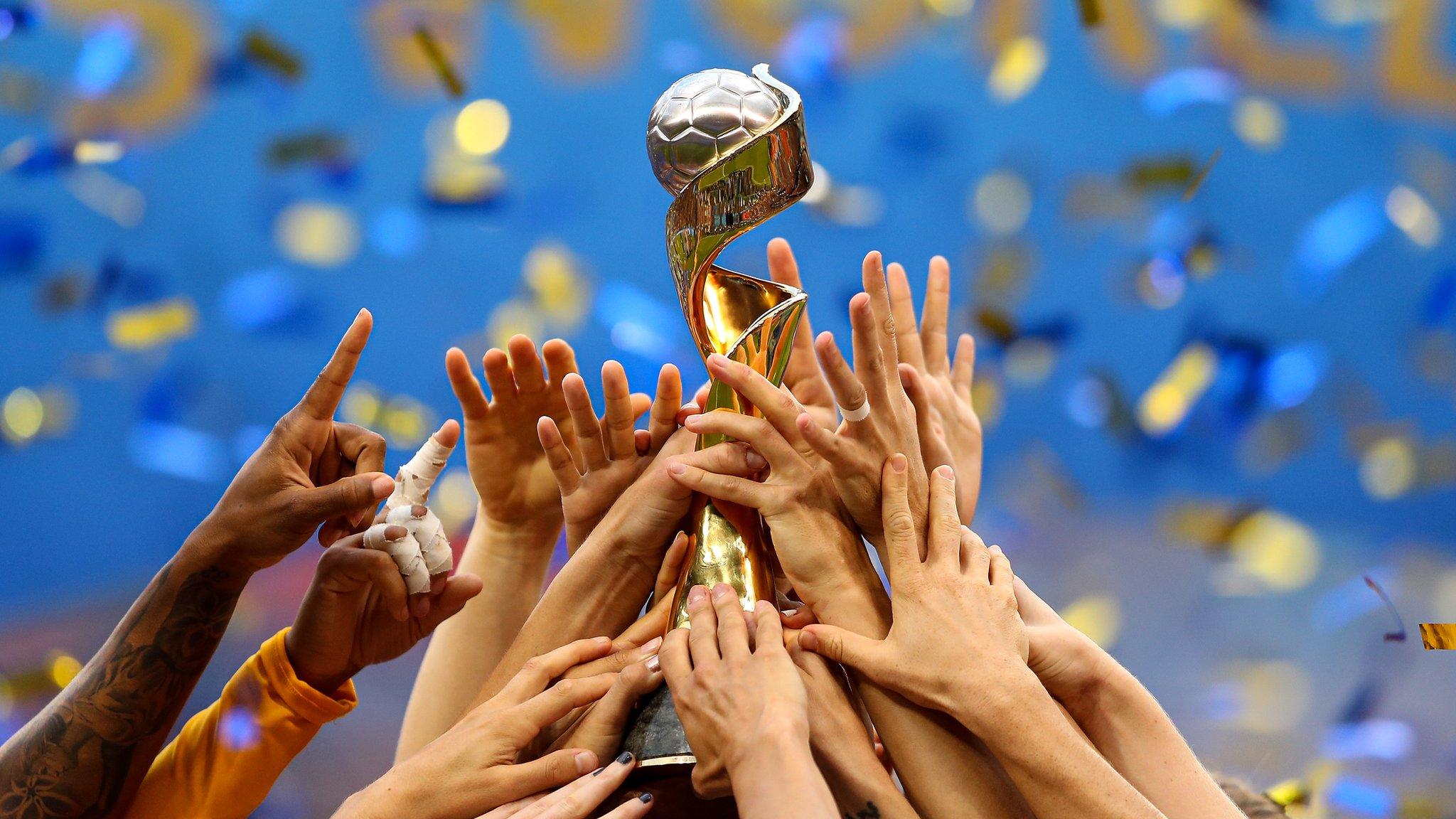 Hands lifting the Women's World Cup trophy