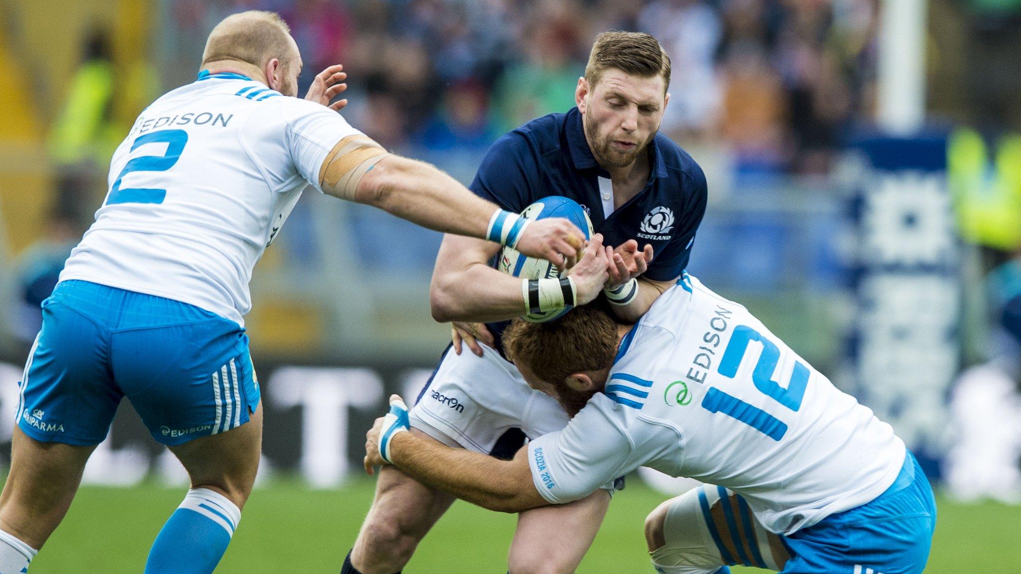 Scotland's Finn Russell is stopped by Italian opponents