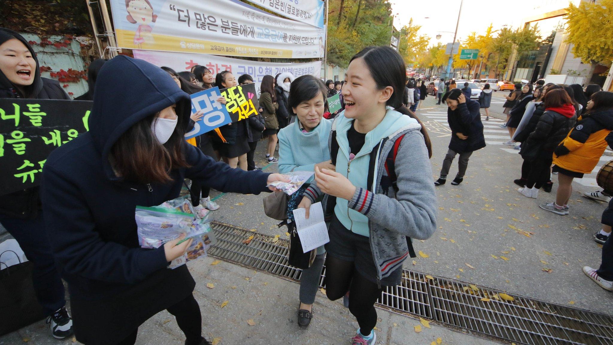 Younger students chanting and handing out sweets as a symbol of good luck