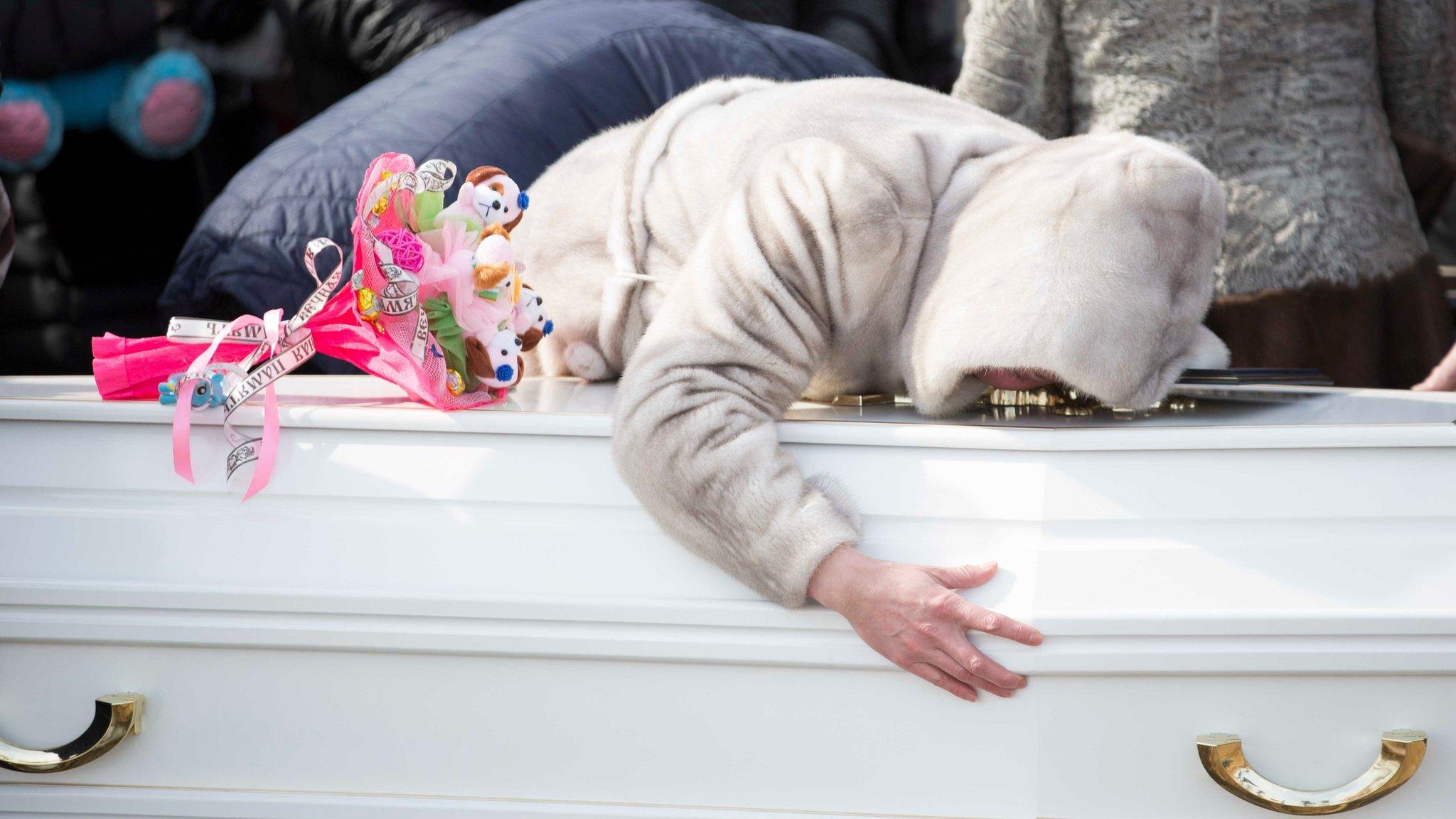 Woman kisses coffin at funeral for one of the victims in the Kemerovo mall fire, on 28 March 2018