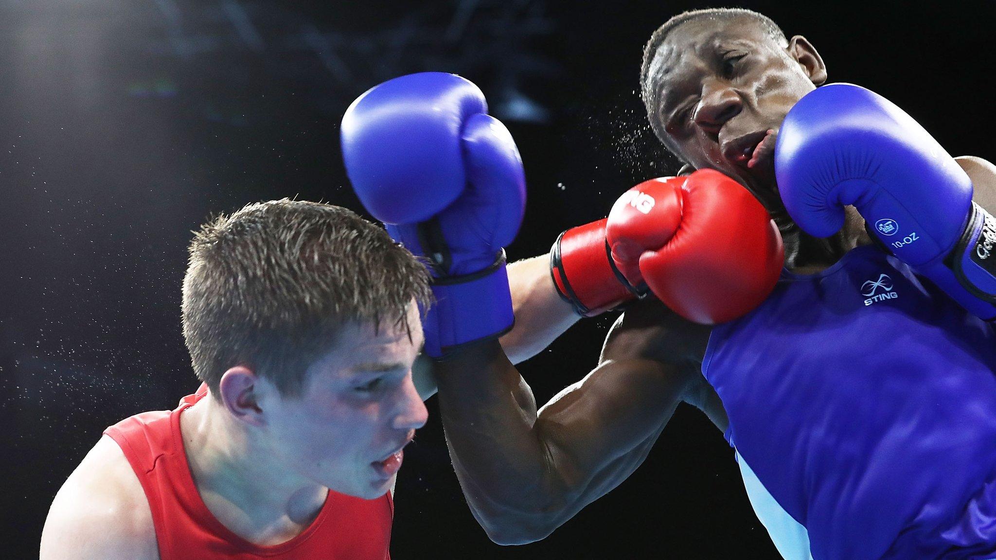 Thomas Blumenfeld of Canada (red) and Jessie Lartey of Ghana (blue) compete in their men's light welter semi-final