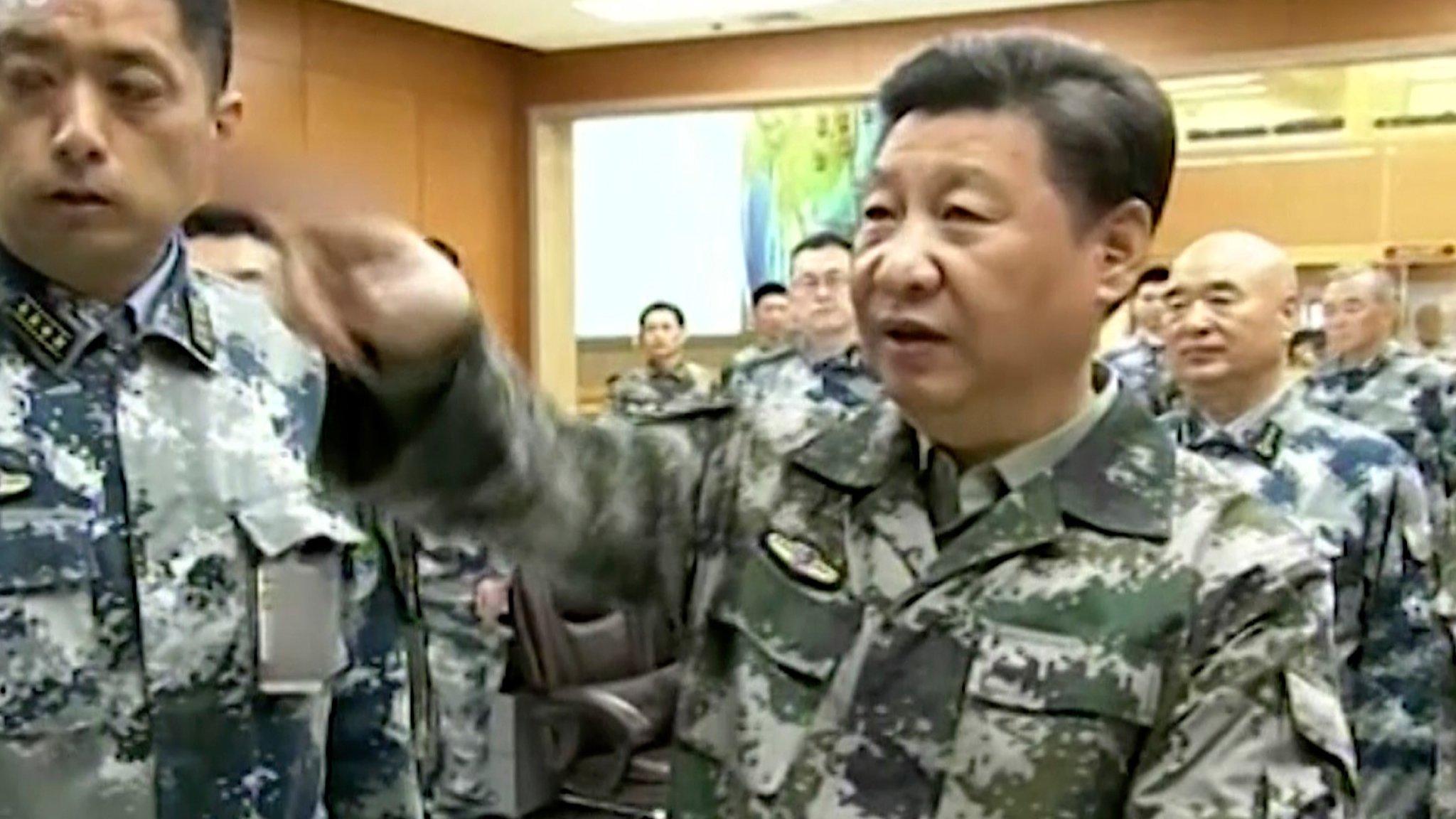 Xi Jinping, in military uniform, gestures during a tour of the military command centre in Beijing, 21 April 2016