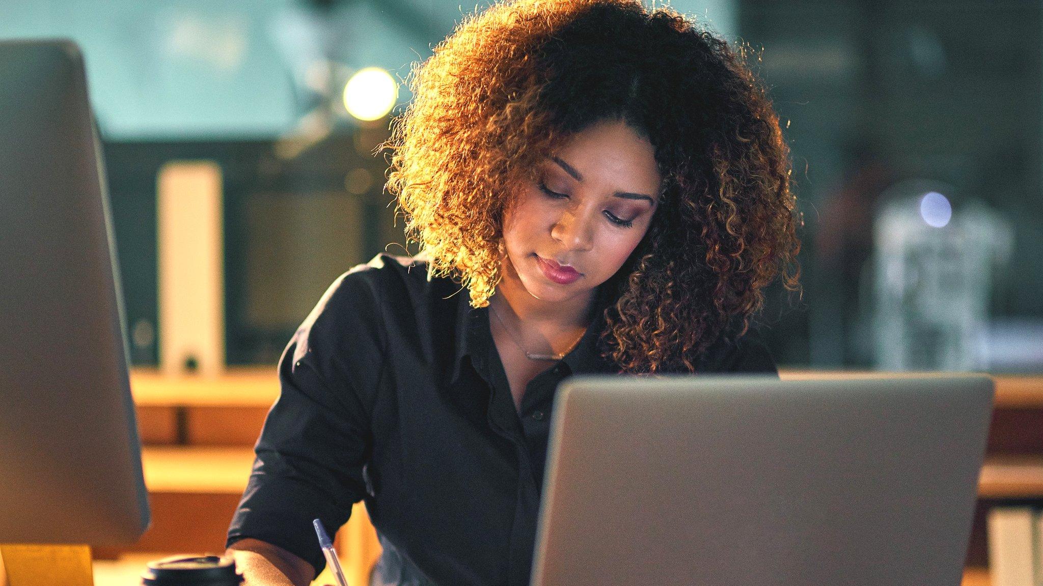 Woman looking at computer and phone