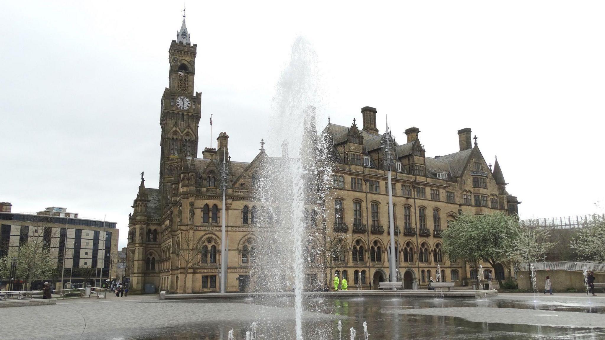 A fountain goes off in front of Bradford City Hall viewed from City Park.