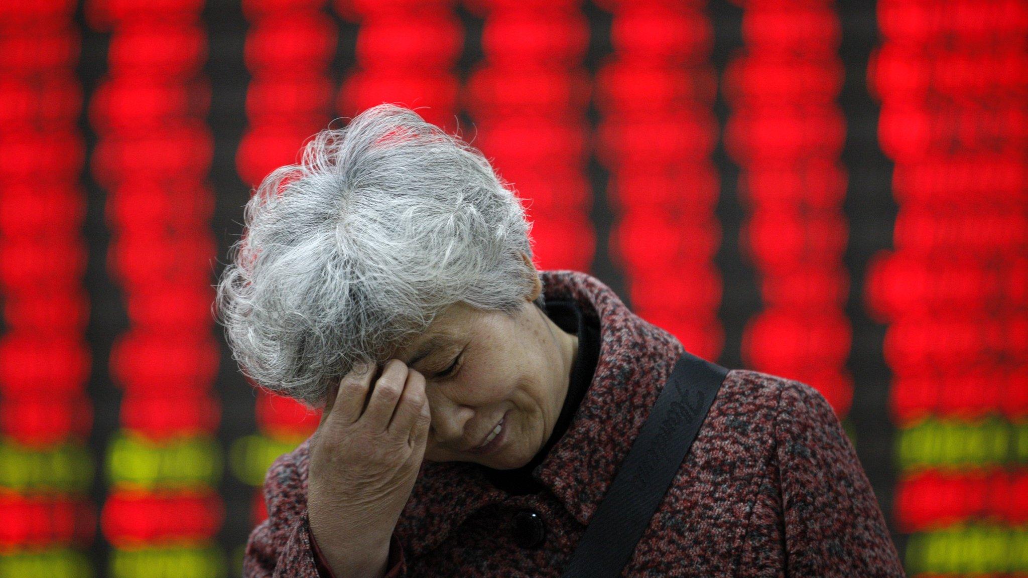 Chinese lady in front of stock price board