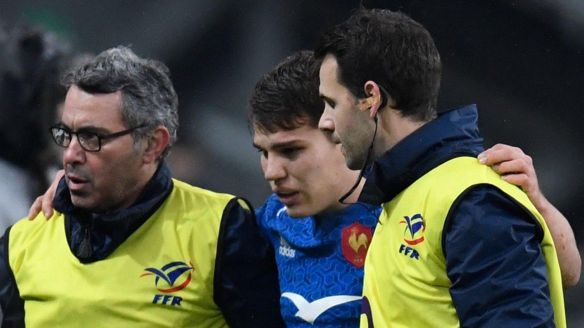 Antoine Dupont is helped from the field by France medics after sustaining an injury against Ireland