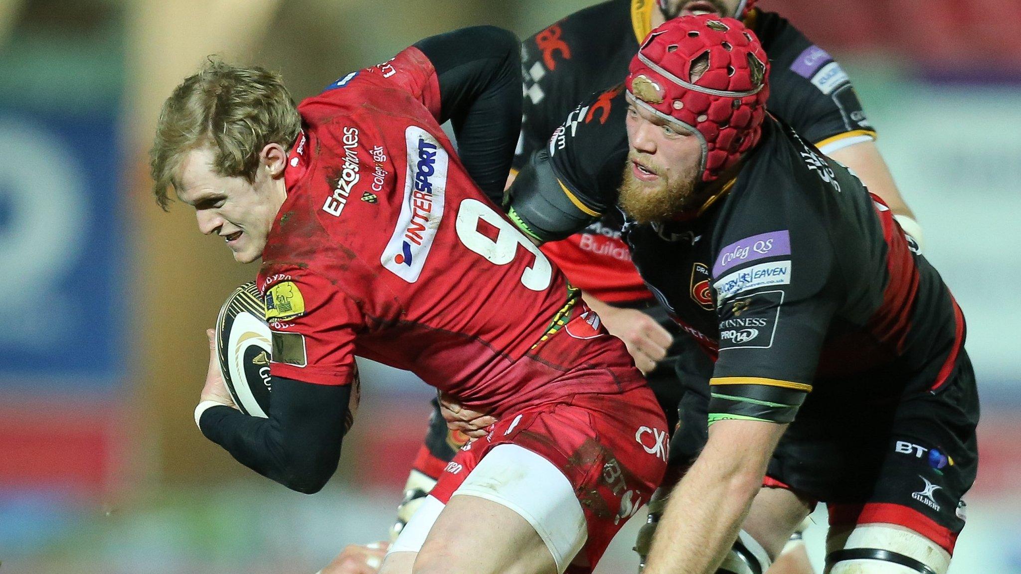 Aled Davies of Scarlets is tackled by Joe Davies